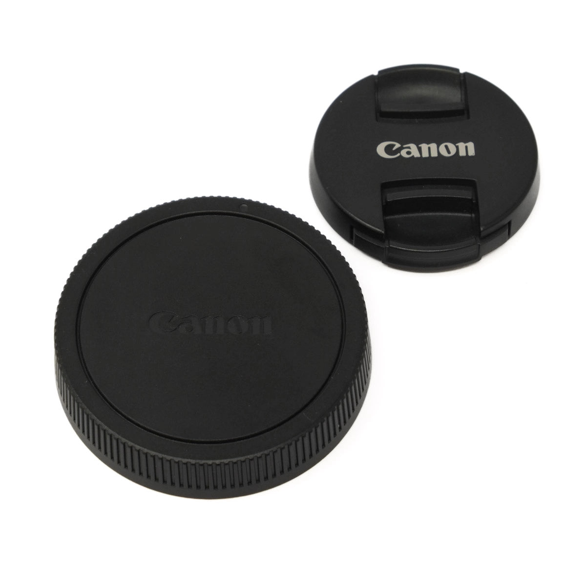Two black Canon lens caps on a white background