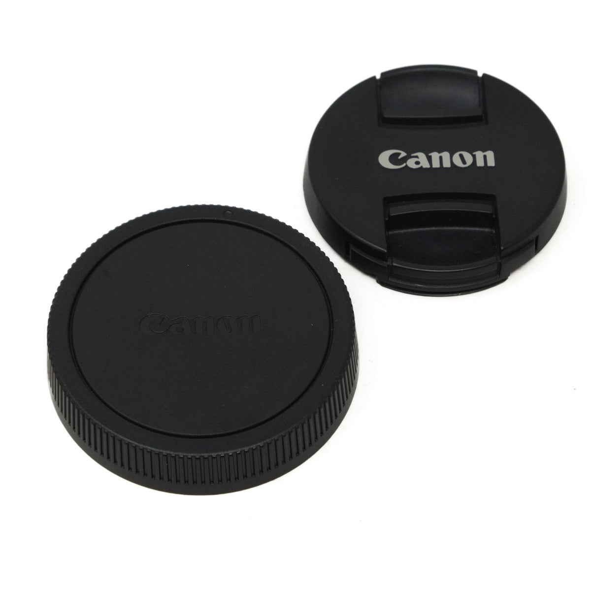 Two black Canon lens caps on a white background