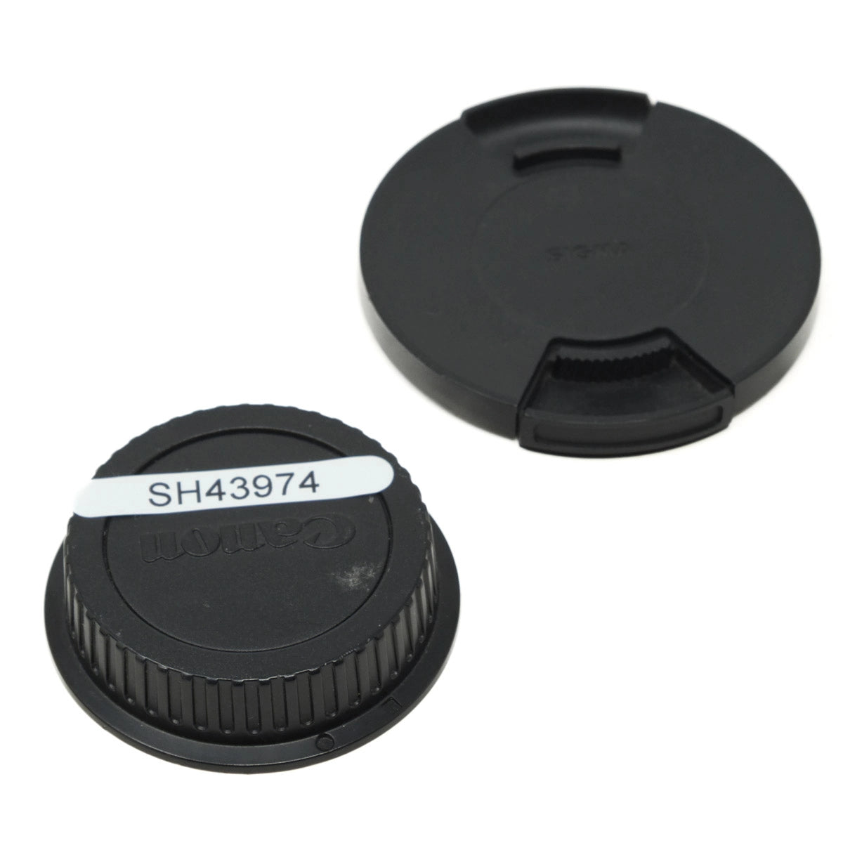 Two black camera lens caps on a white background