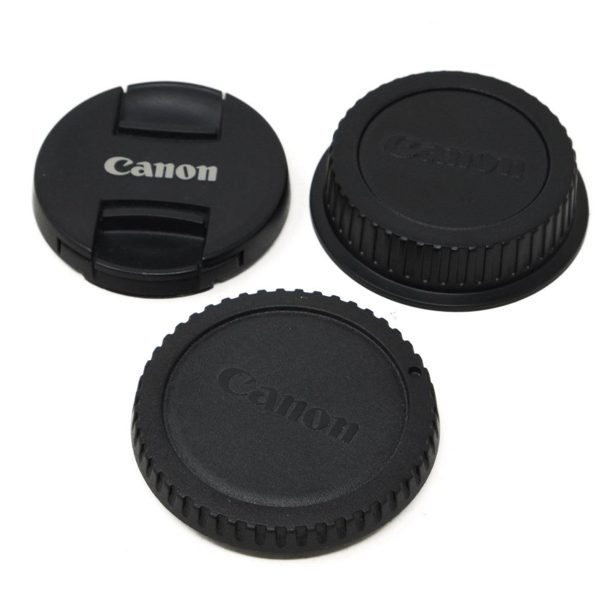 Three Canon camera caps on a white background