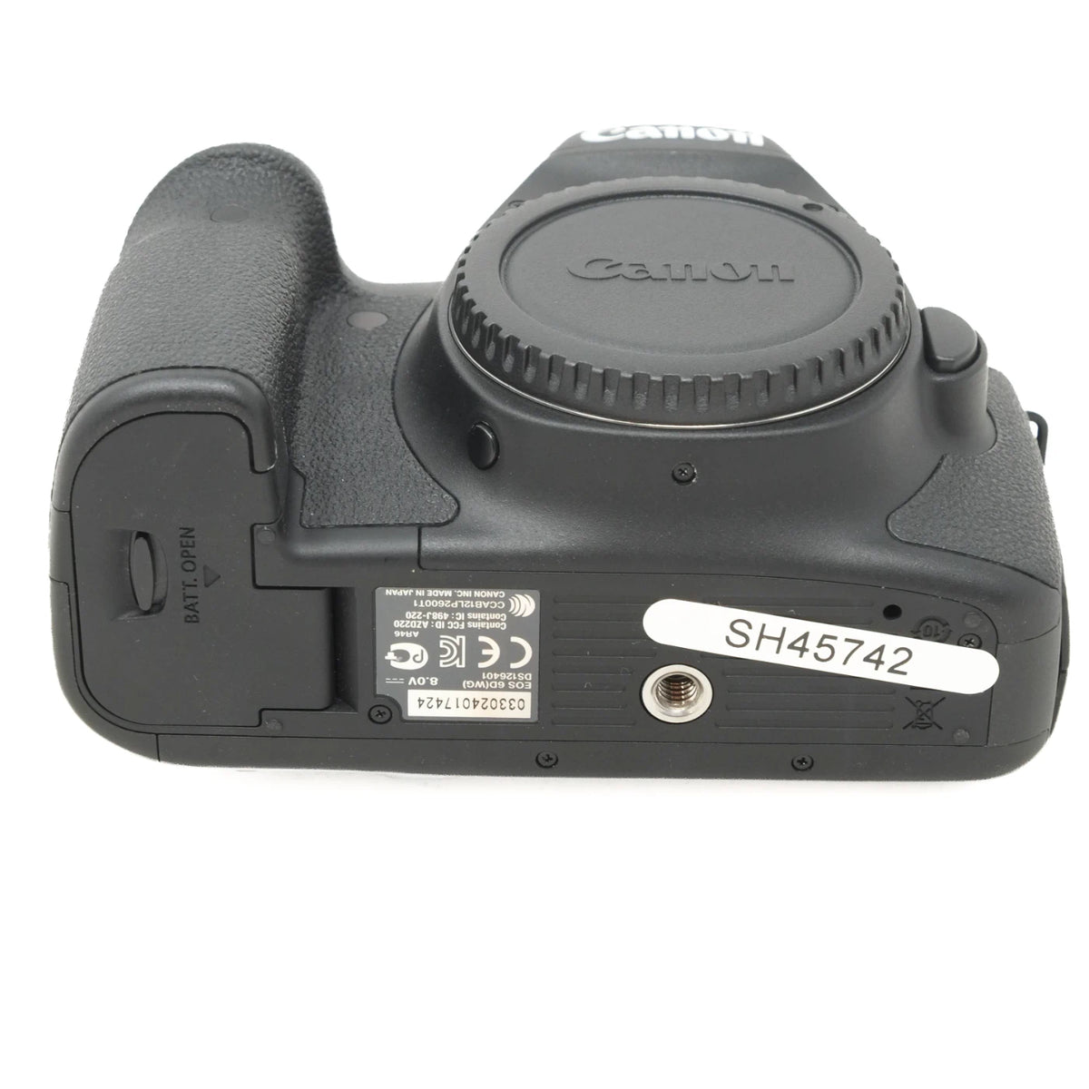 Canon DSLR camera body rear view with a black lens cap, textured grip, and a white serial number sticker reading SH45742 on a white background.