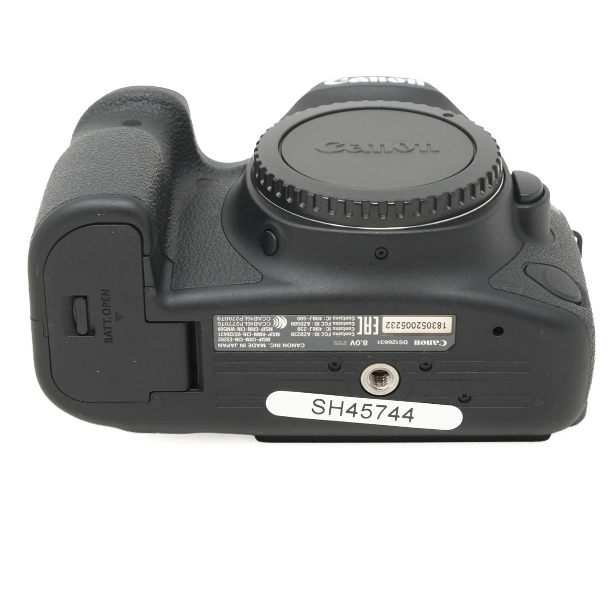 Canon DSLR camera body rear view with the lens cap removed, showing the grip, battery compartment, and model information label on a white background.