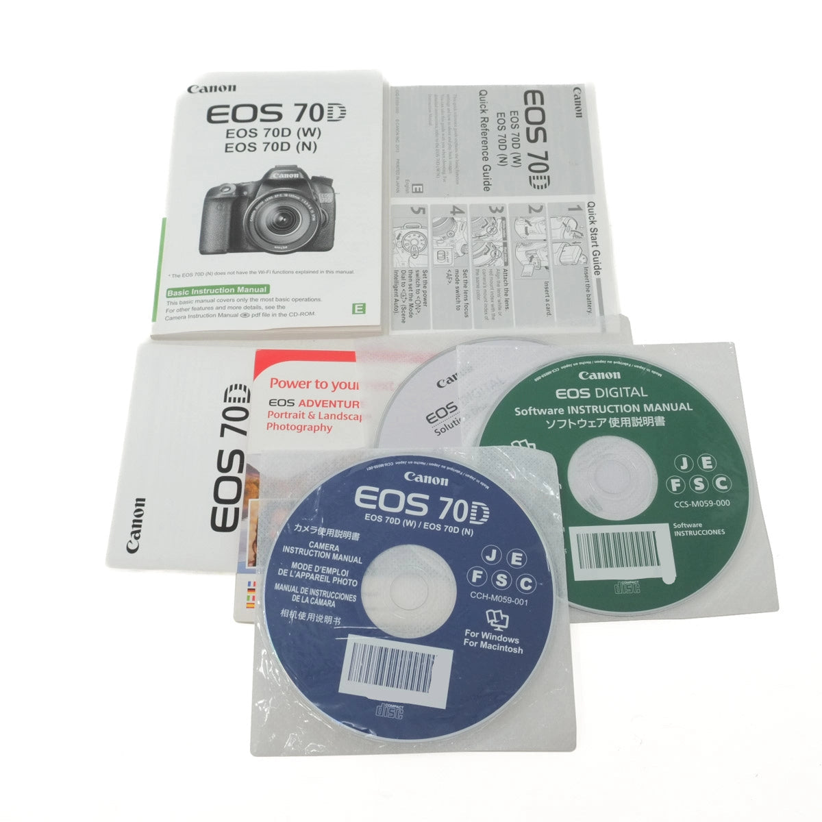 Canon EOS 70D camera manual and software discs on a white background