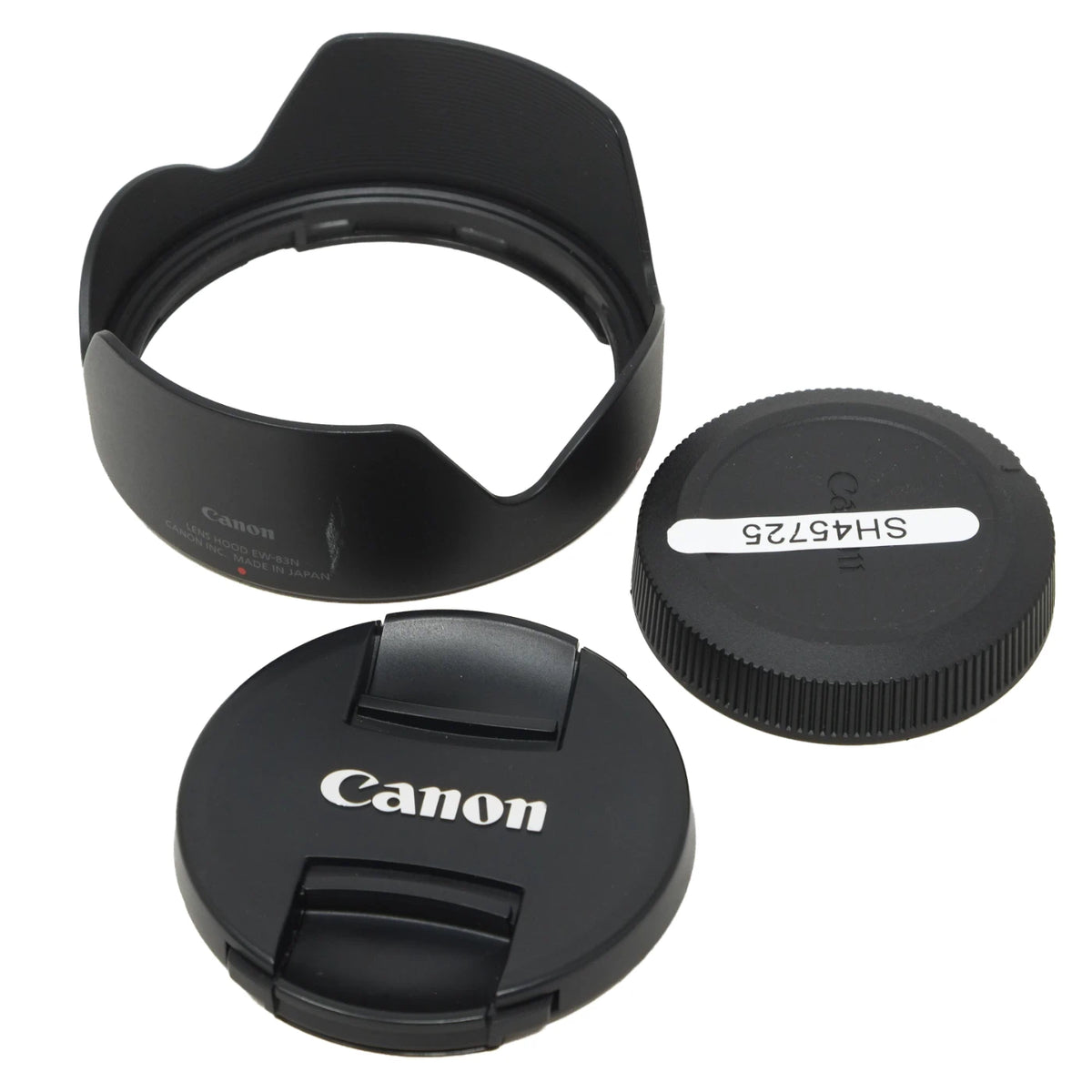 Canon lens accessory set on a white background, including a petal-shaped lens hood, a Canon lens cap with white Canon logo, and a threaded lens cap with a white label reading SH45725.