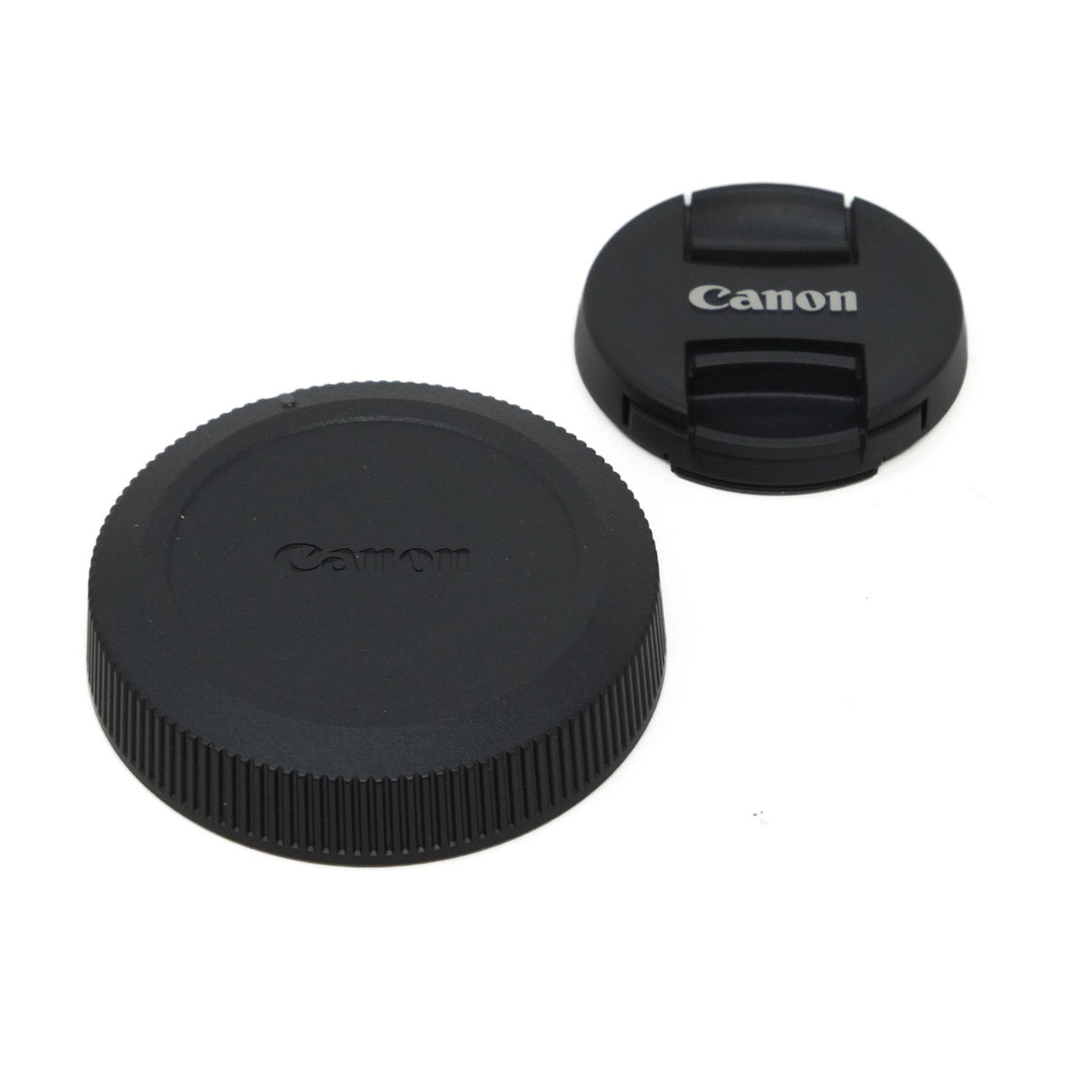 Two black Canon lens caps on a white background