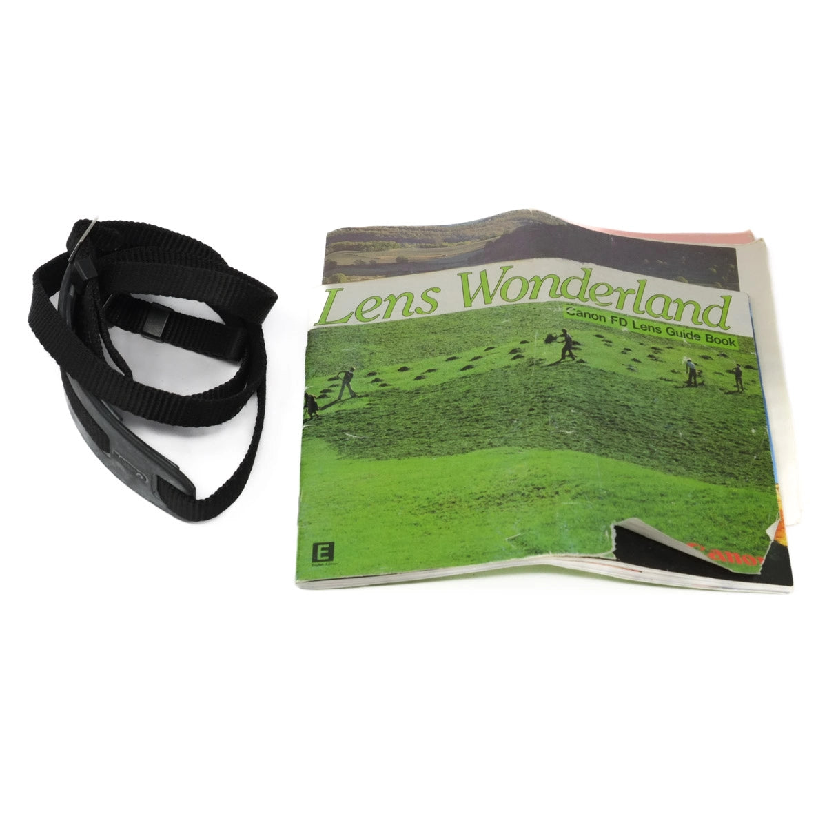 Book titled 'Lens Wonderland' with a black strap on a white background