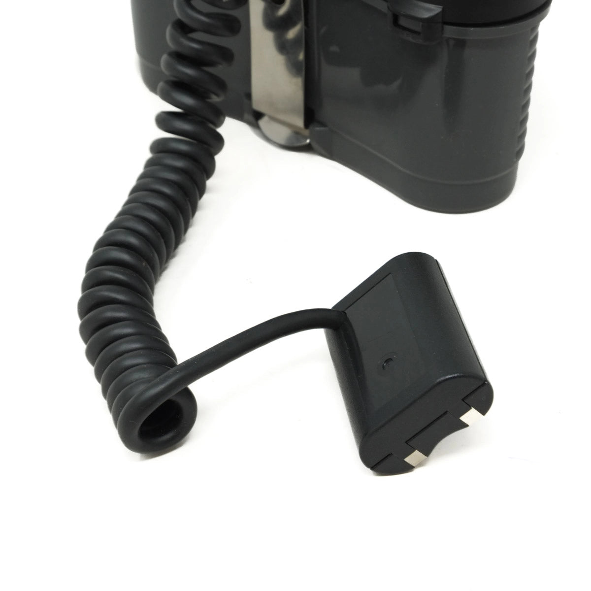 Black coiled cable attached to a device on a white background