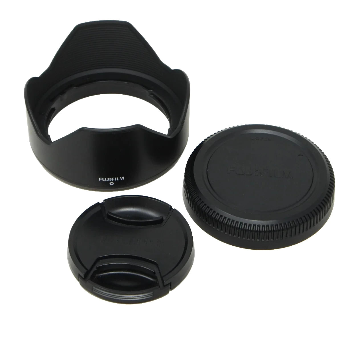 Black Fujifilm lens accessories including a petal-shaped lens hood, a lens cap, and a separate inner cap, shown on a white background.
