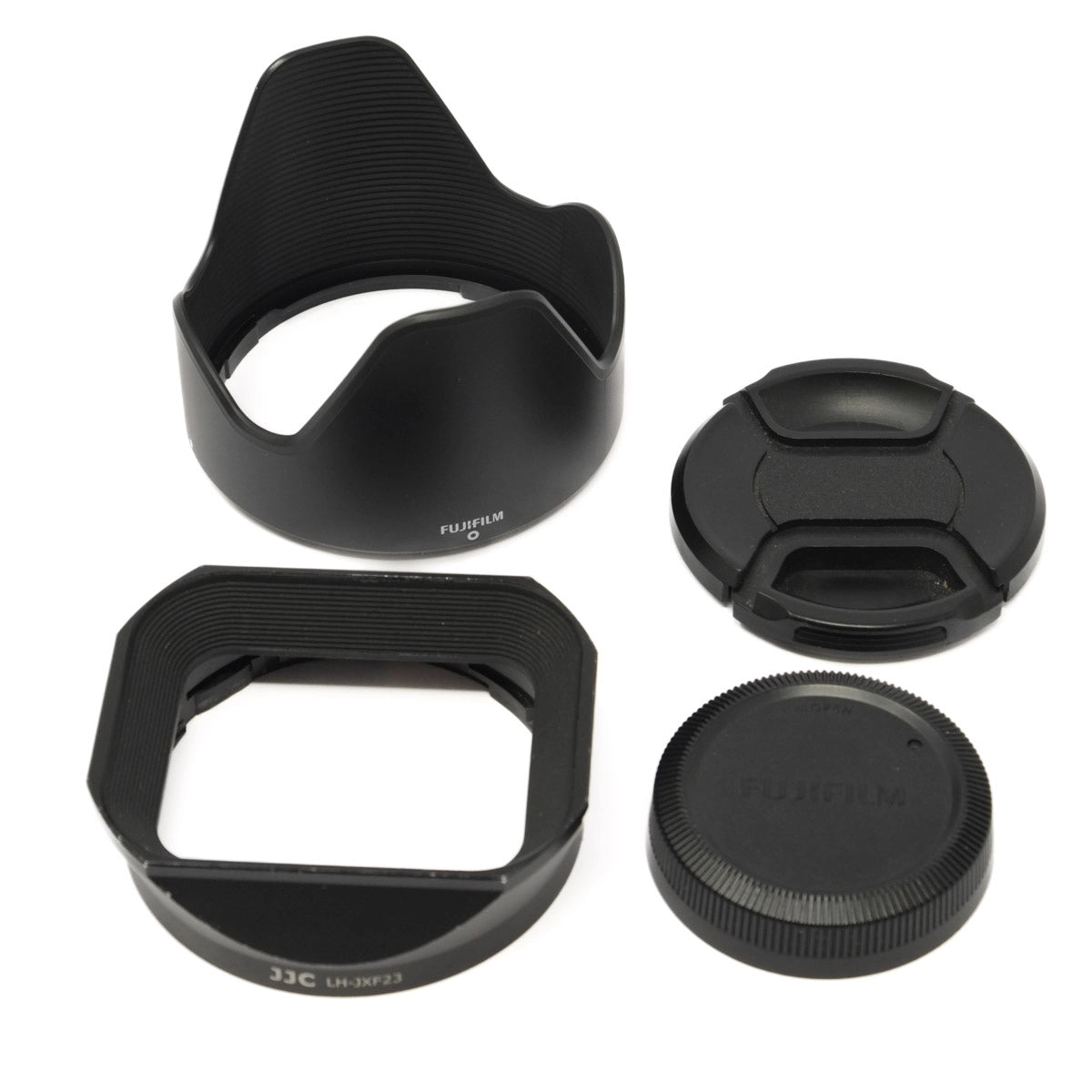 Set of camera lens accessories including lens hoods and front and rear caps on a white background