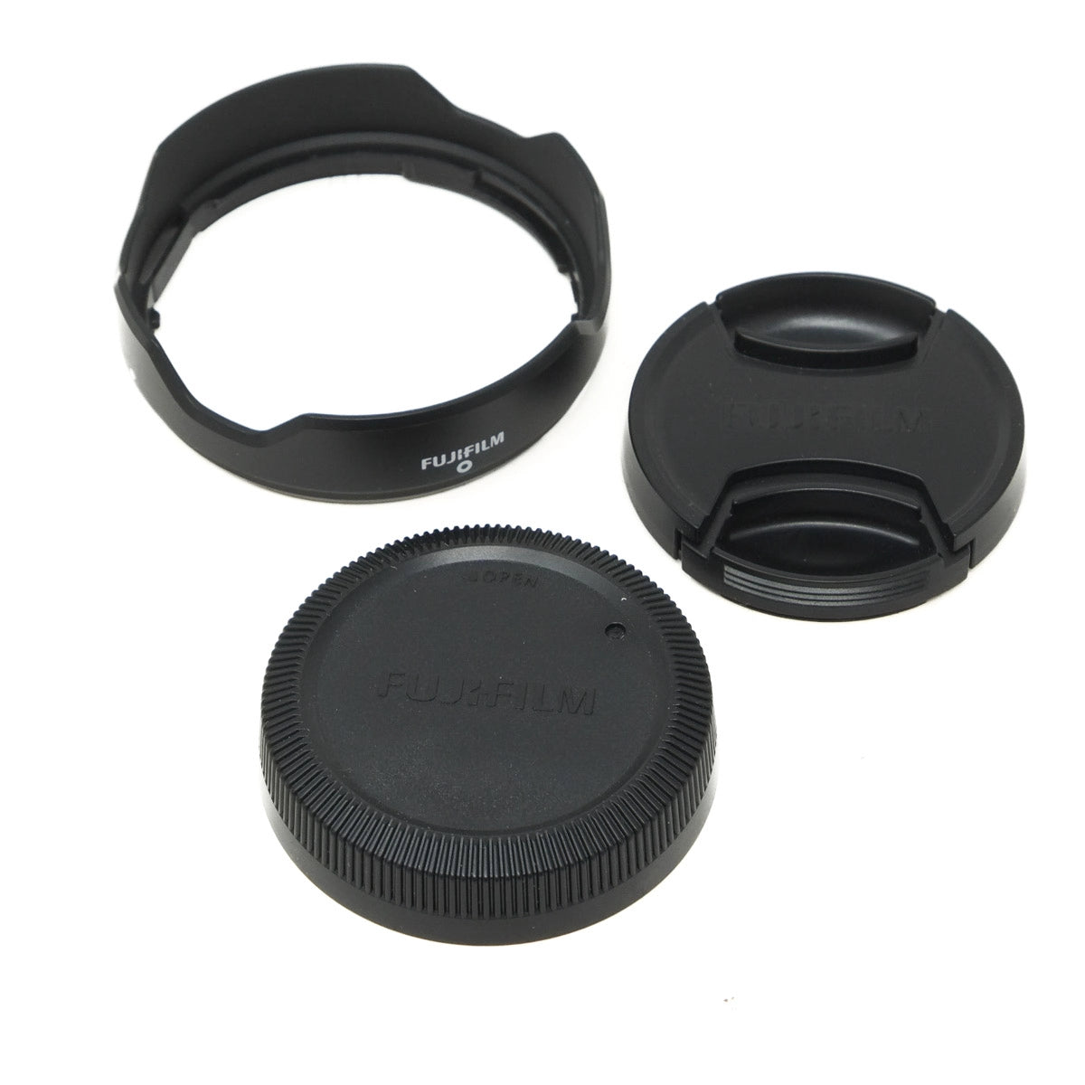 Set of Fujifilm camera lens caps and hood on a white background