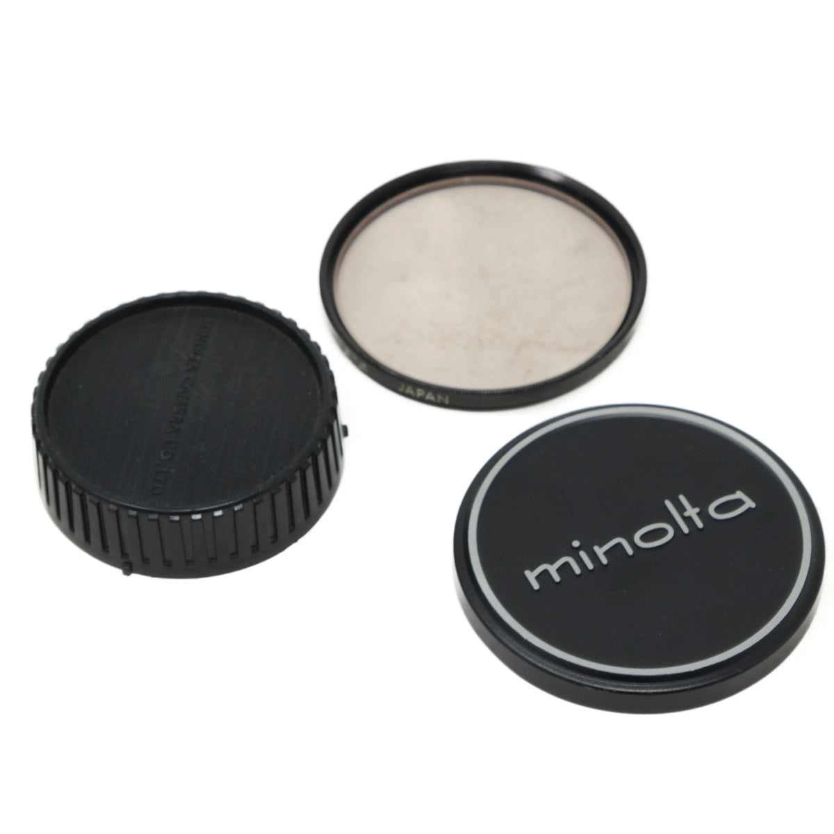 Minolta camera lens cap and filter on a white background