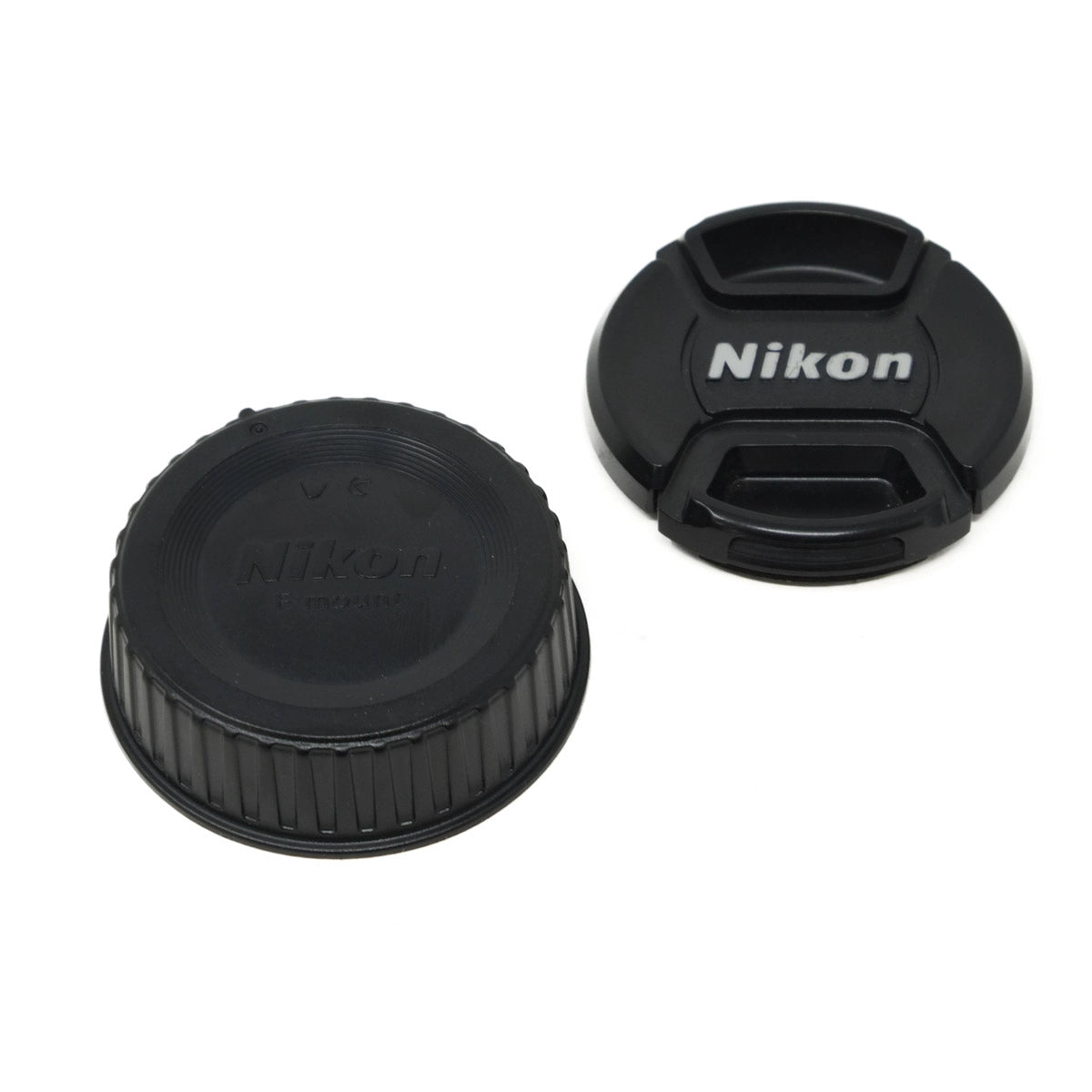 Two black Nikon lens caps on a white background