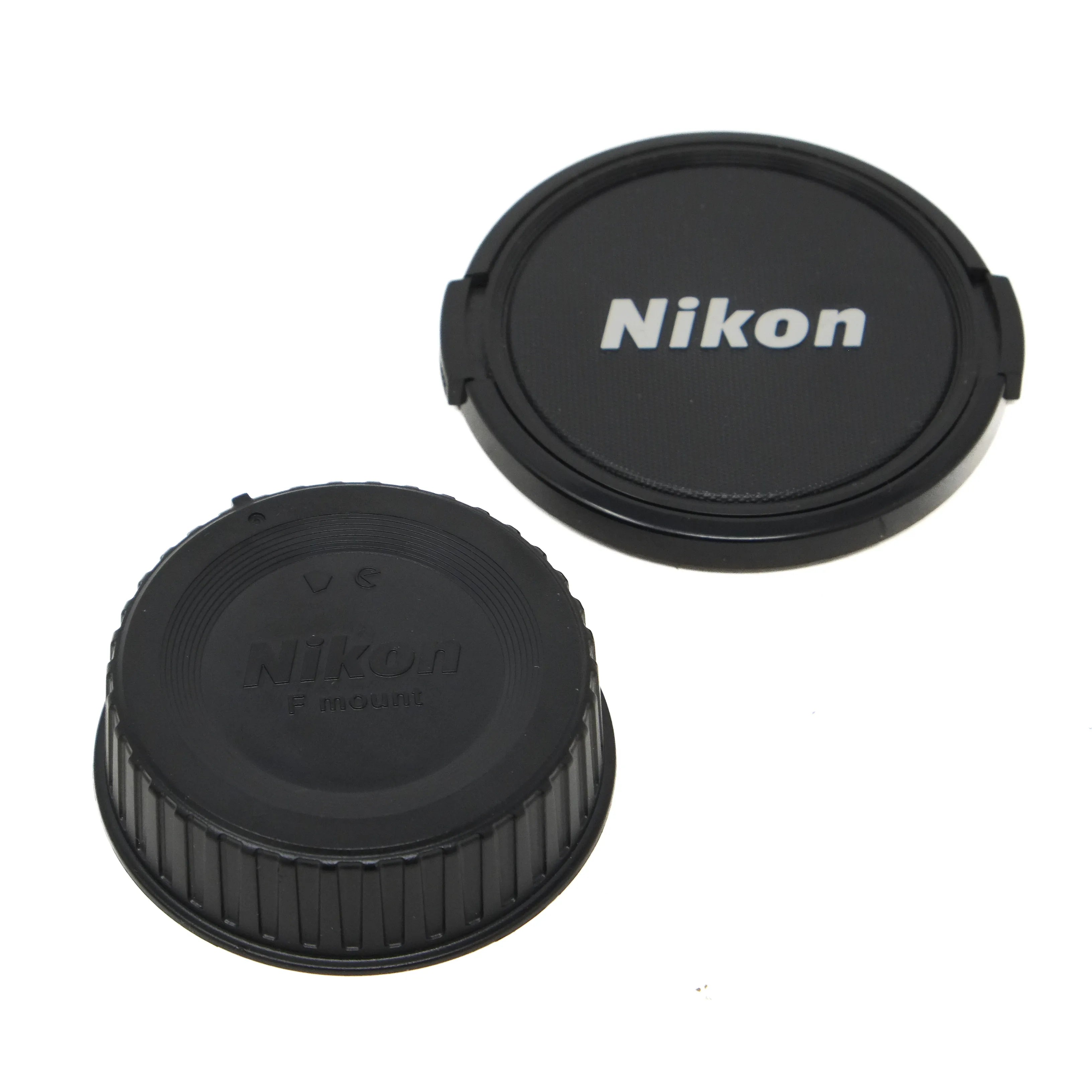 Two Nikon lens caps on a white background