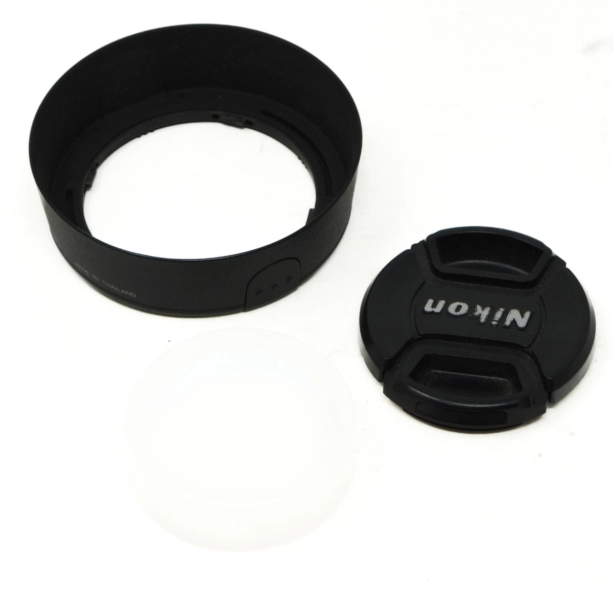 Black camera lens caps and hood on a white background