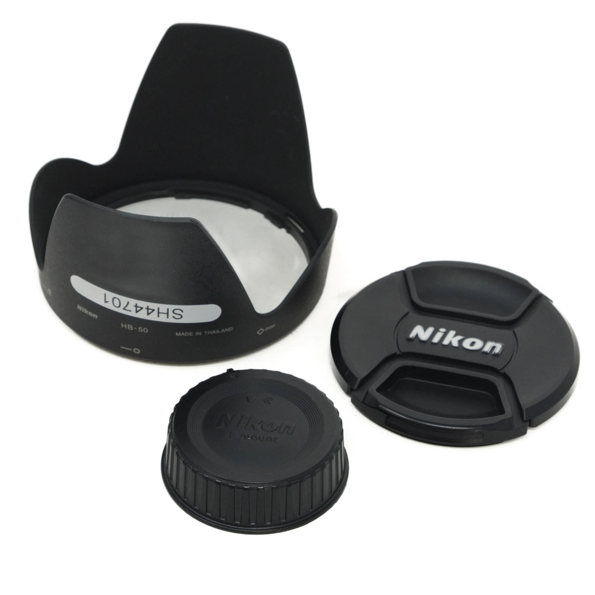 Camera lens accessories including a lens hood, front and rear caps on a white background