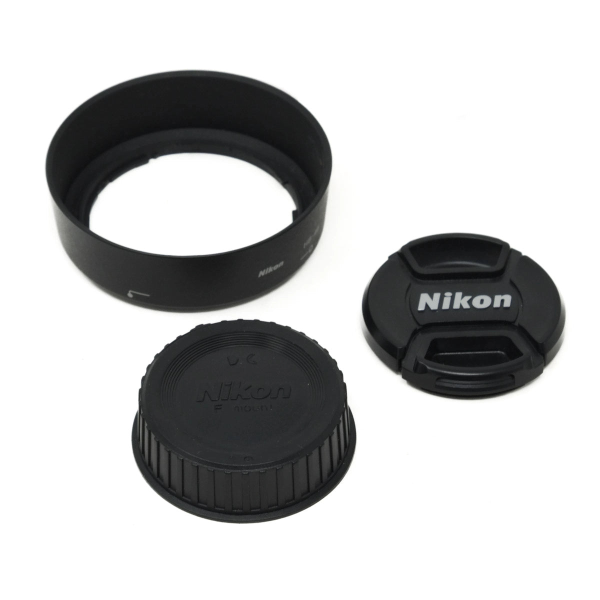 Nikon camera lens accessories including a lens hood, front and rear caps on a white background
