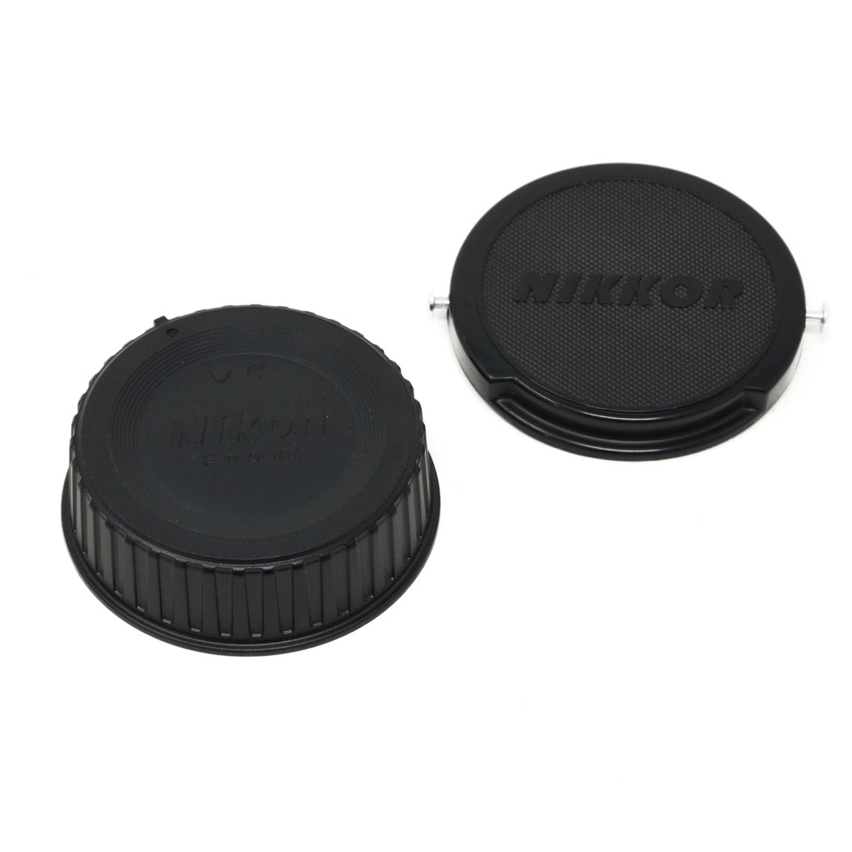 Two black Nikon lens caps on a white background