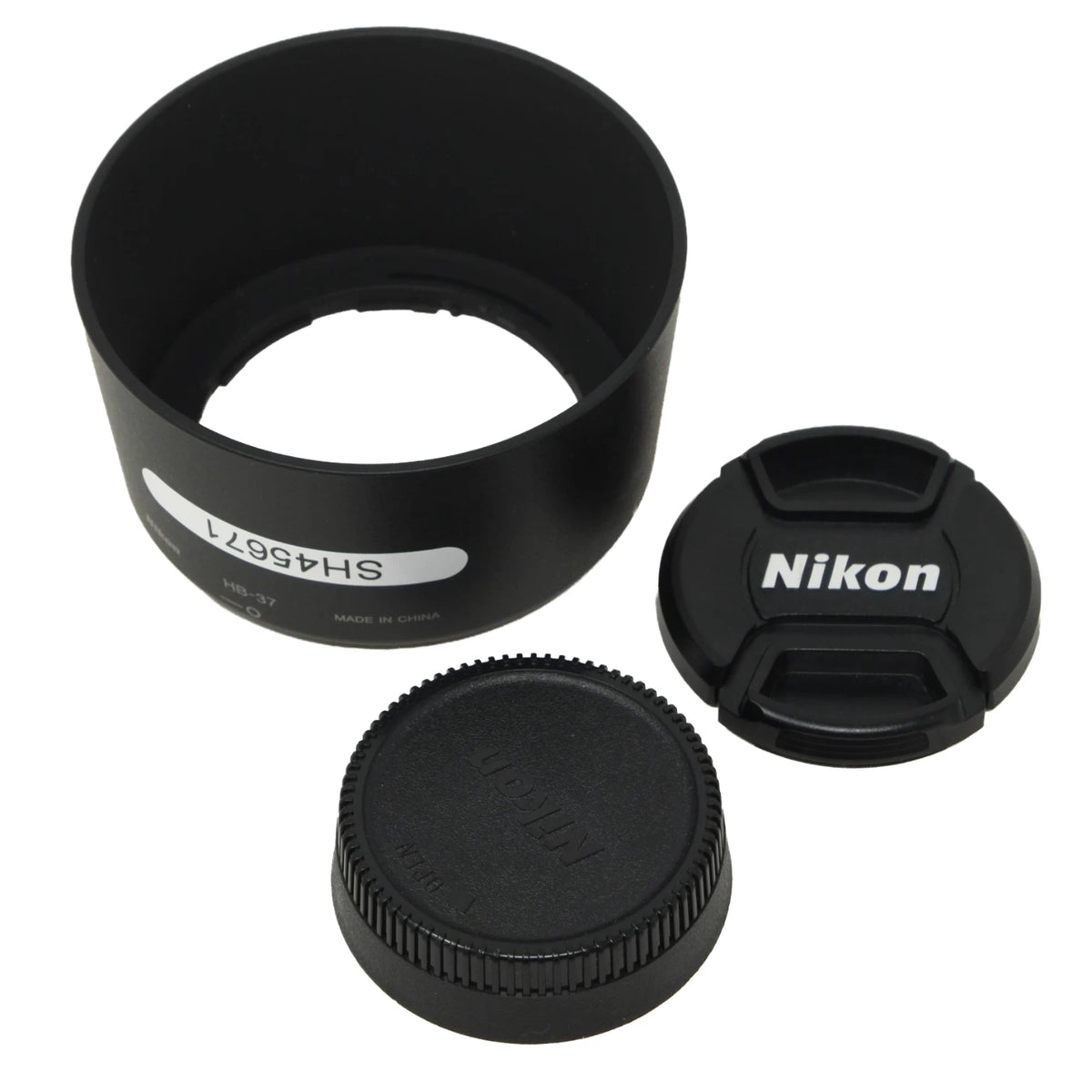 Nikon lens accessory set including a black lens hood, a Nikon-branded lens cap, and a ribbed black lens cover, shown on a white background.