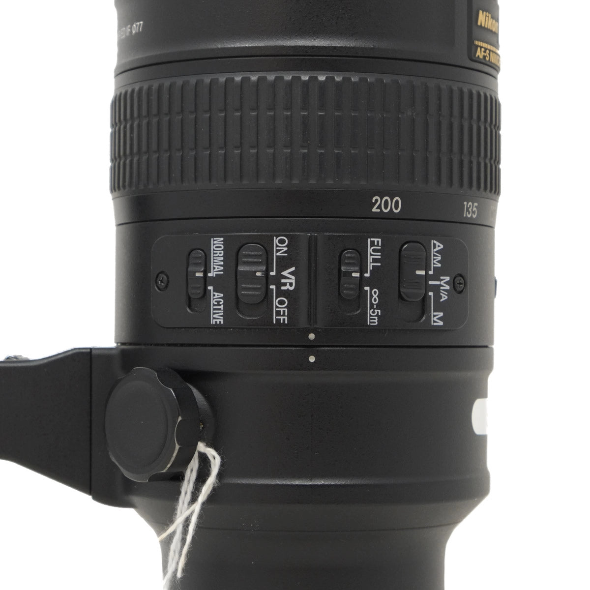 Close-up of a Nikon camera lens with control buttons on a white background