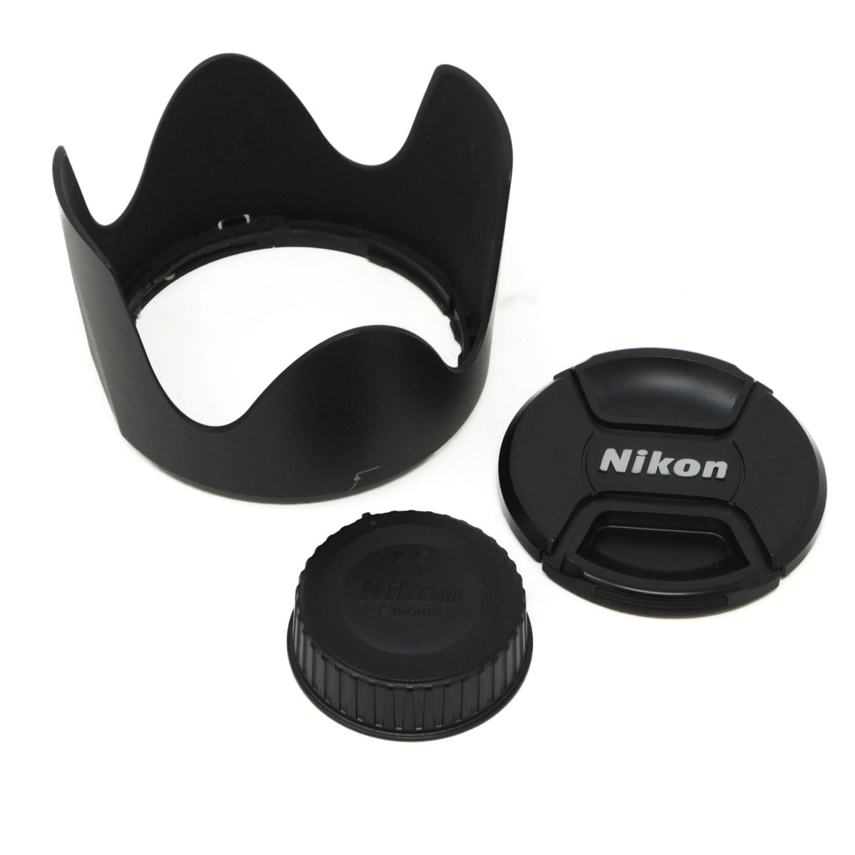 Camera lens accessories including a hood, cap, and lens cover on a white background