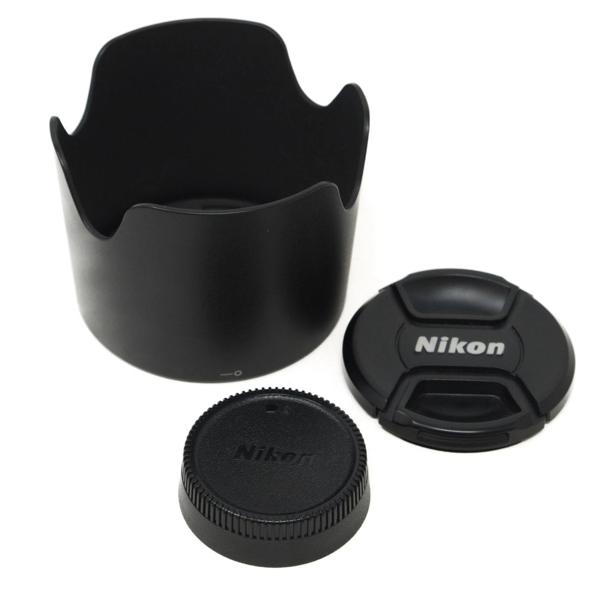 Nikon lens accessories including a lens hood, front and rear caps on a white background