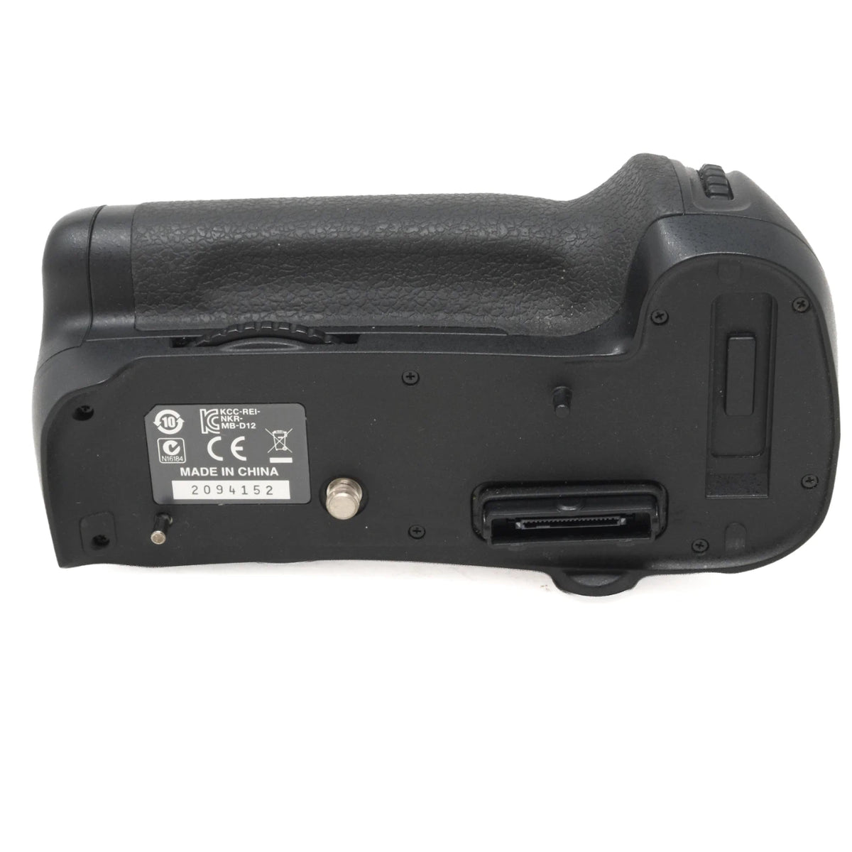 The underside of a black Nikon battery grip handle, showing the textured grip, a product serial sticker, on a white background.