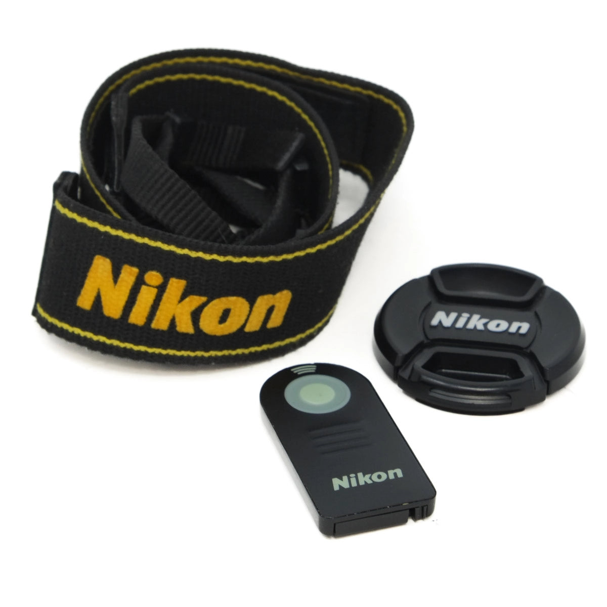 Nikon camera strap, lens cap, and remote control on a white background