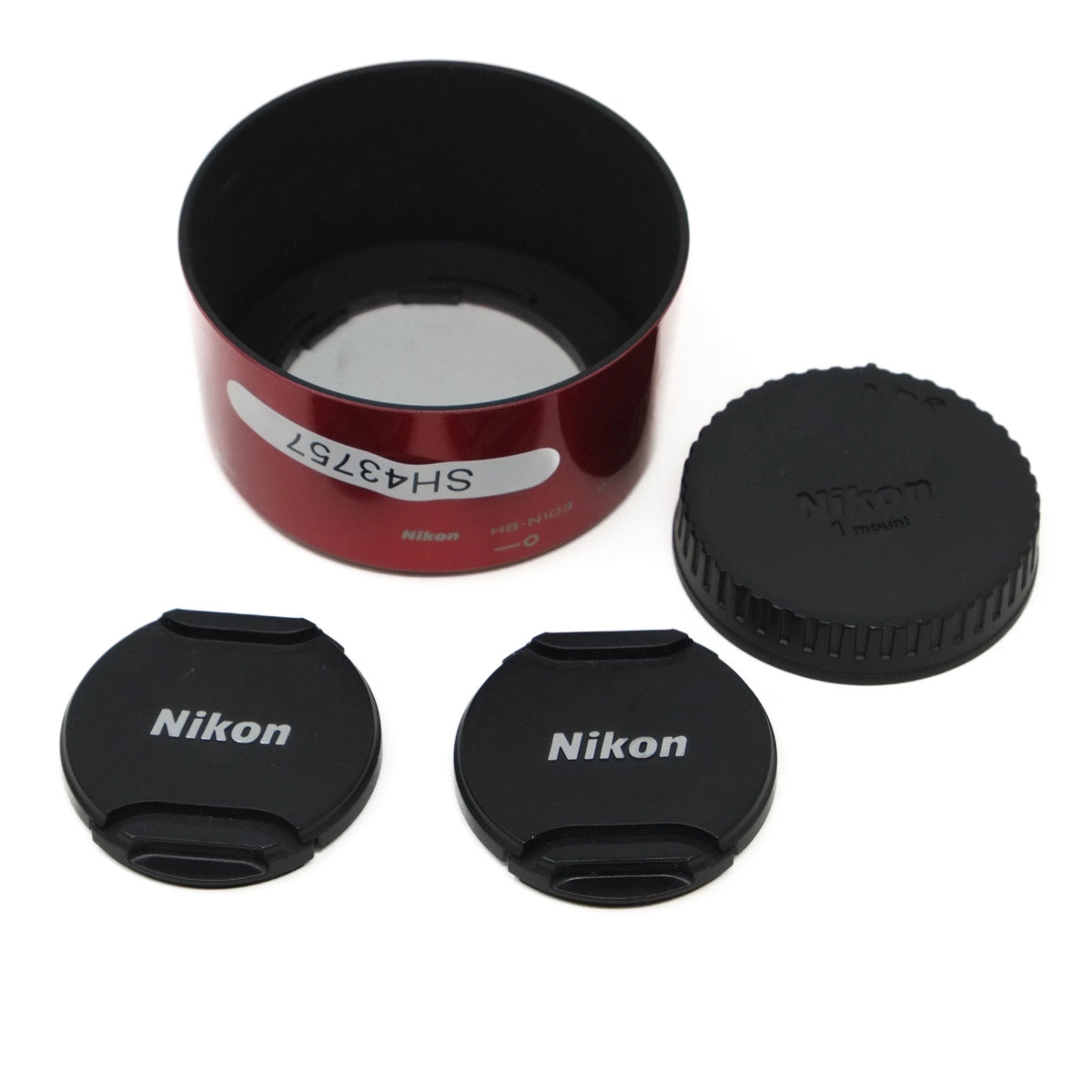Nikon lens cap set with a lens hood and red case on a white background