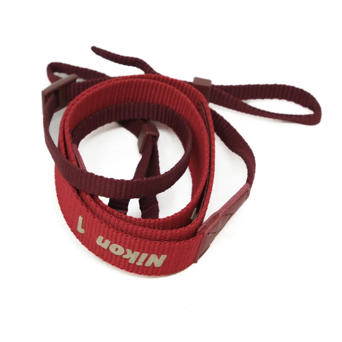 Red Nikon camera strap on a white background