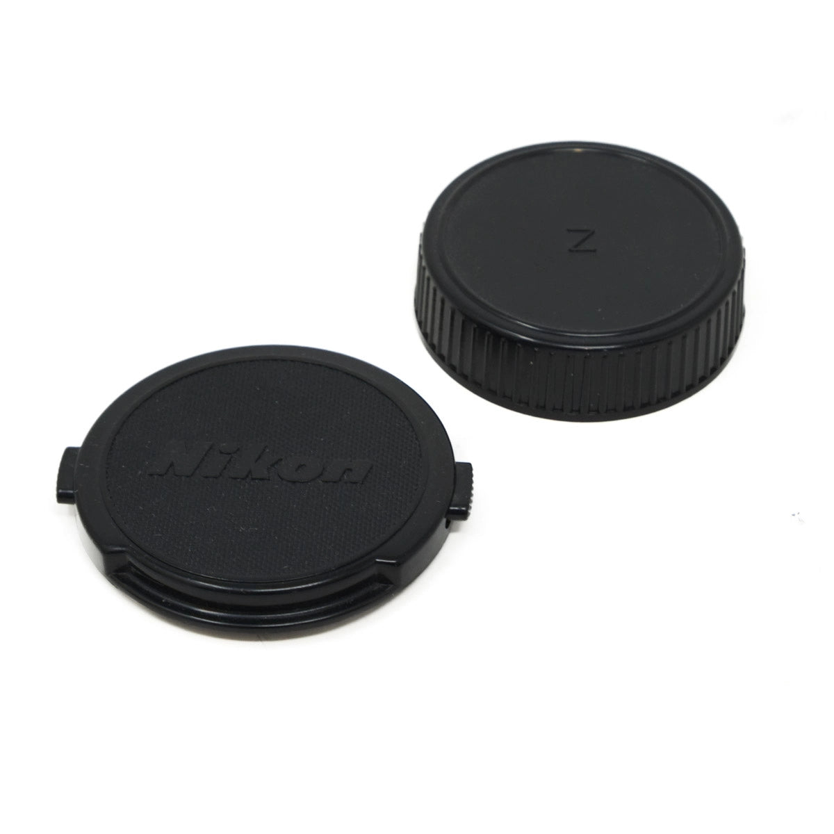 Two black Nikon lens caps on a white background