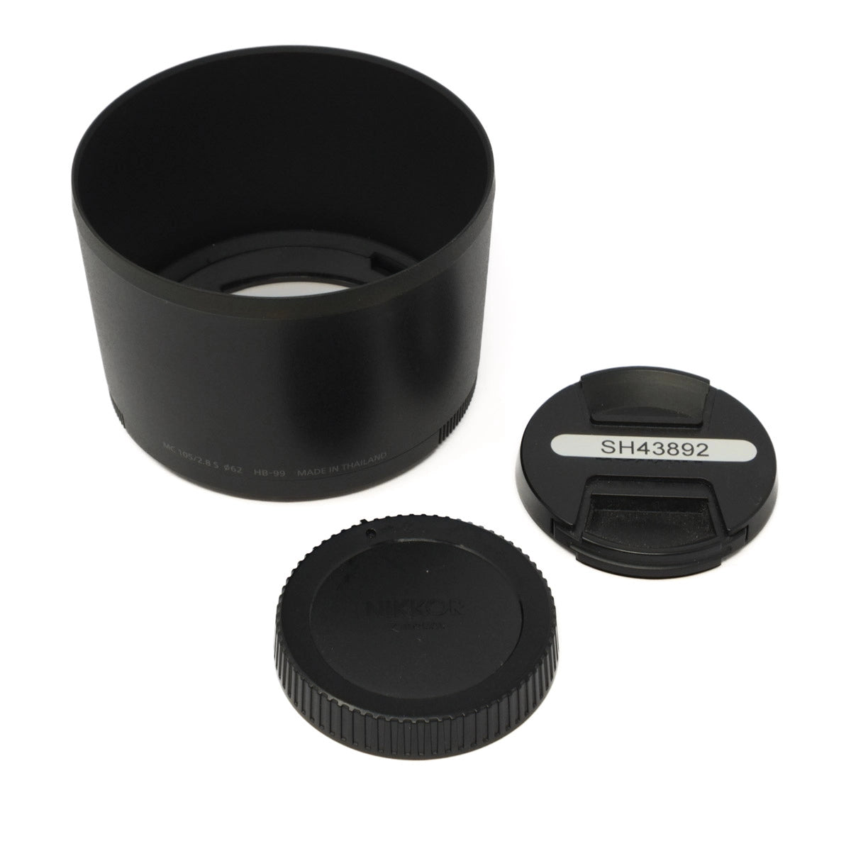 Black camera lens hood and two caps on a white background