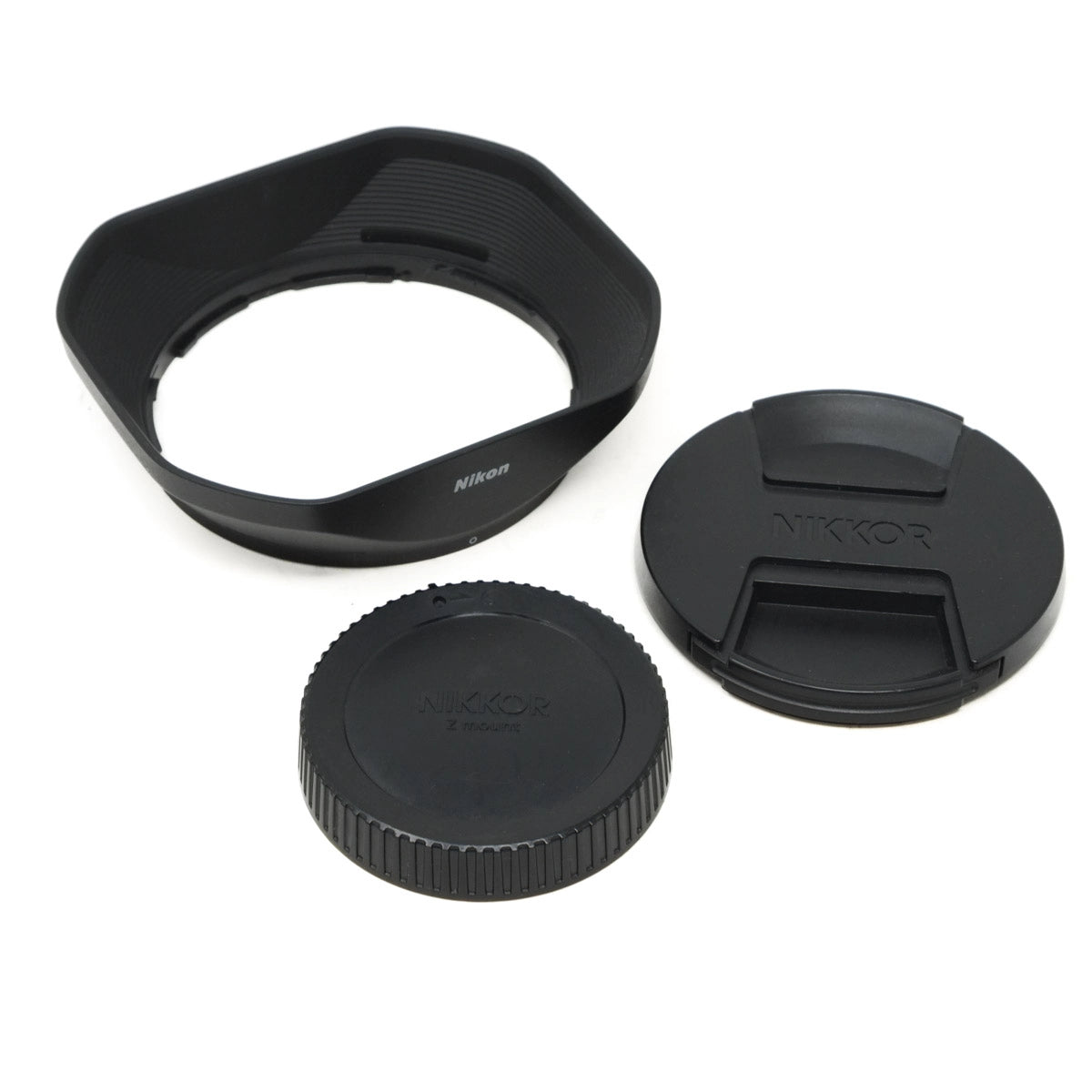 Camera lens hood, front cap, and rear cap on a white background