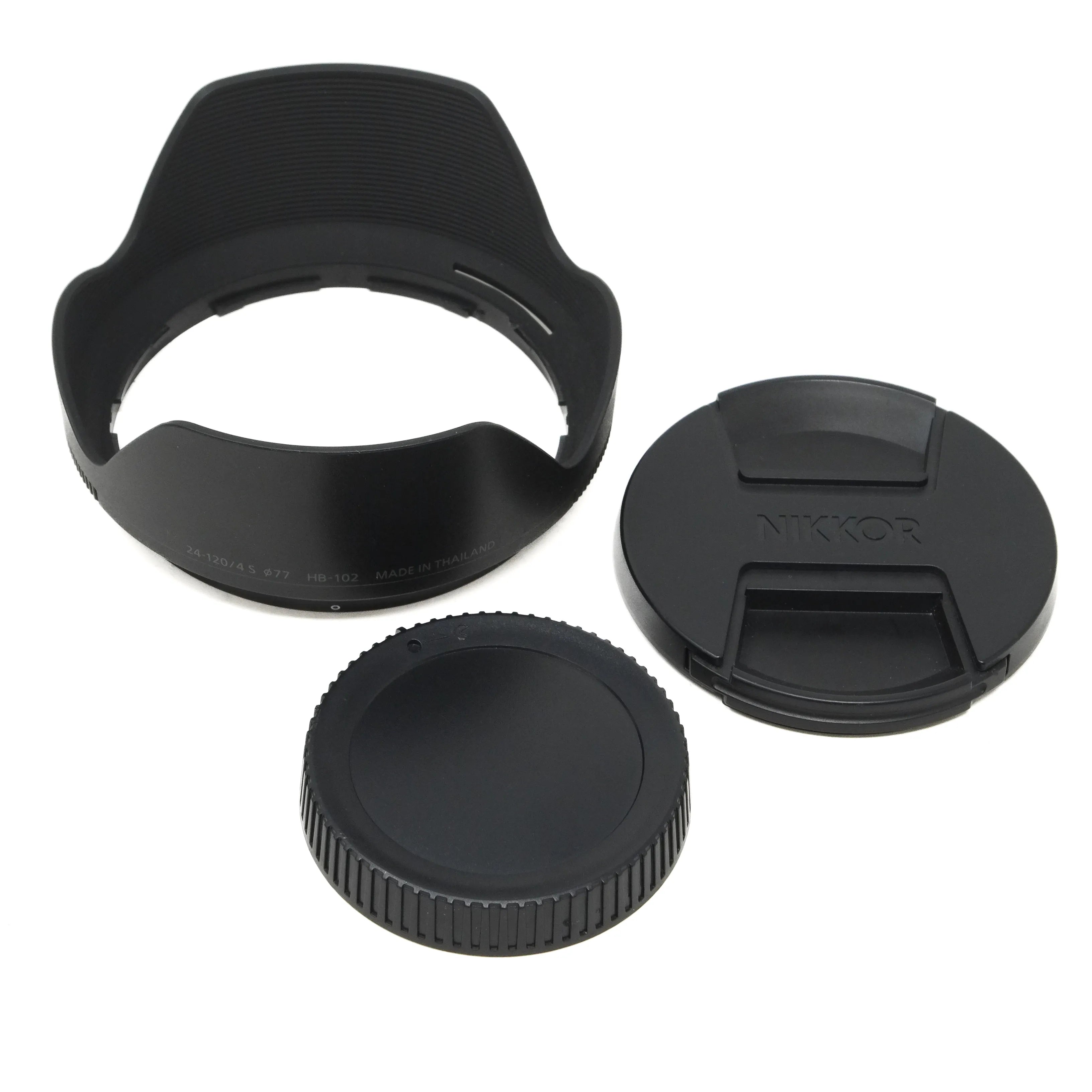 Camera lens accessories including a lens hood, front and rear caps on a white background
