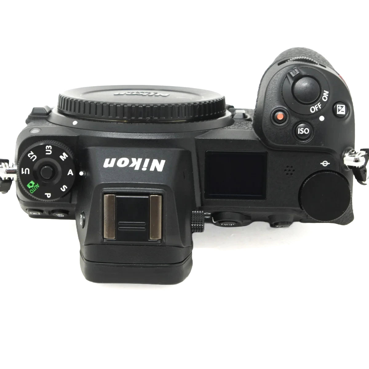 Top-down view of a Nikon mirrorless camera body, showing the mode dial on the left, the lens mount, the LCD screen, and the control buttons on the right, photographed on a white background.