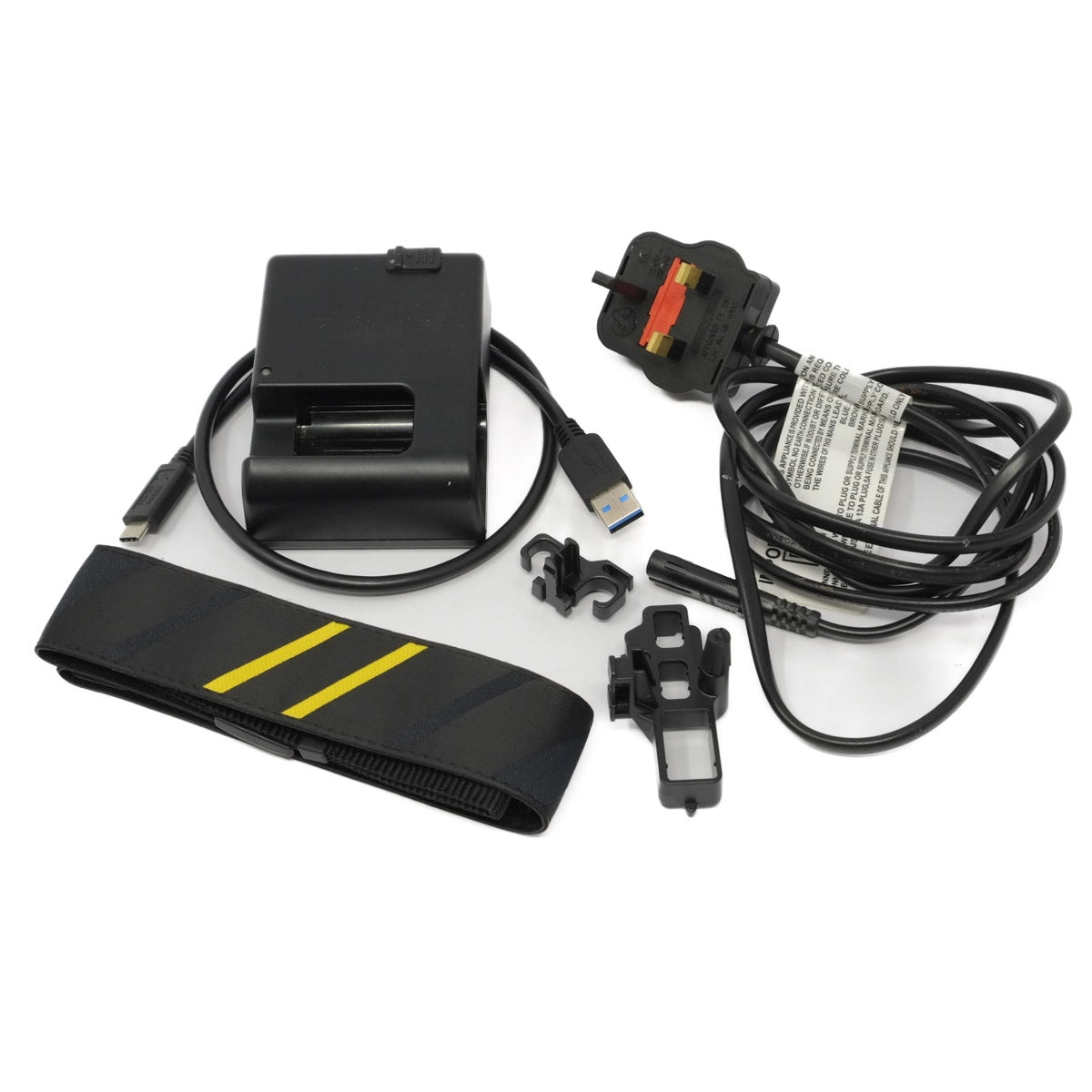 Collection of electronic components including a charger, cables, and mounting accessories and strap on a white background.