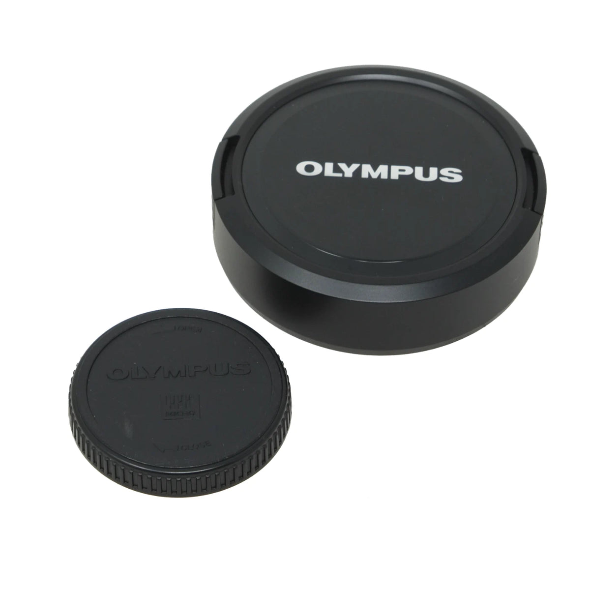 Two black Olympus camera lens caps on a plain white background, with one cap standing upright and the other lying flat showing the embossed brand name.