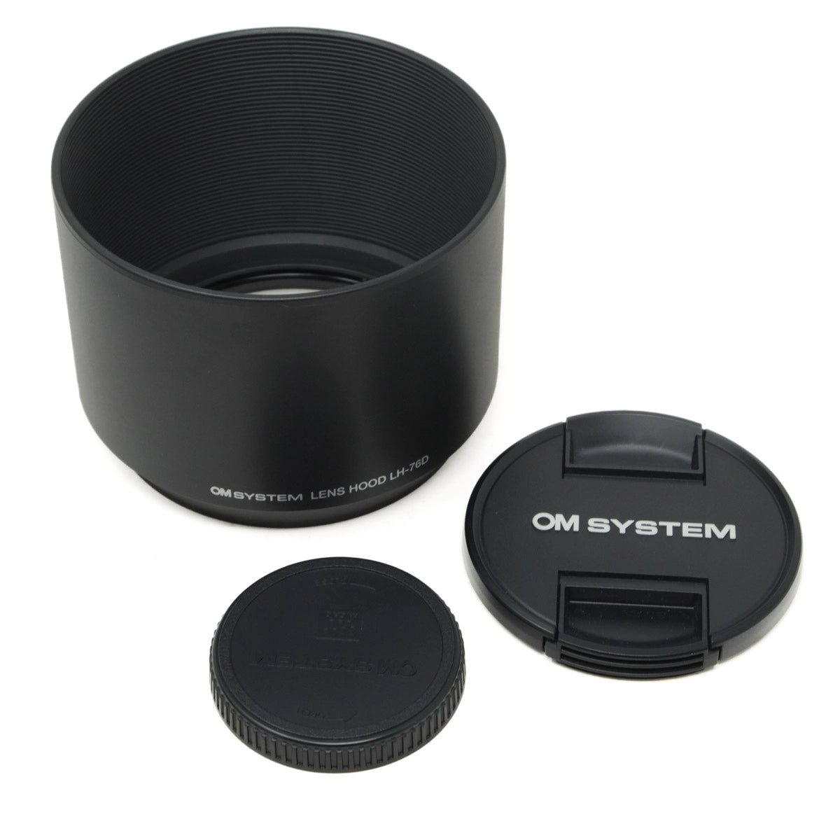 Black camera lens hood and cap with 'OM System' branding on a white background