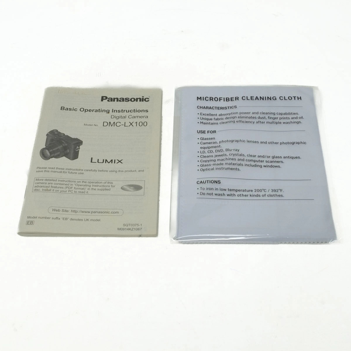 Panasonic digital camera operating instructions and microfiber cleaning cloth on a white background