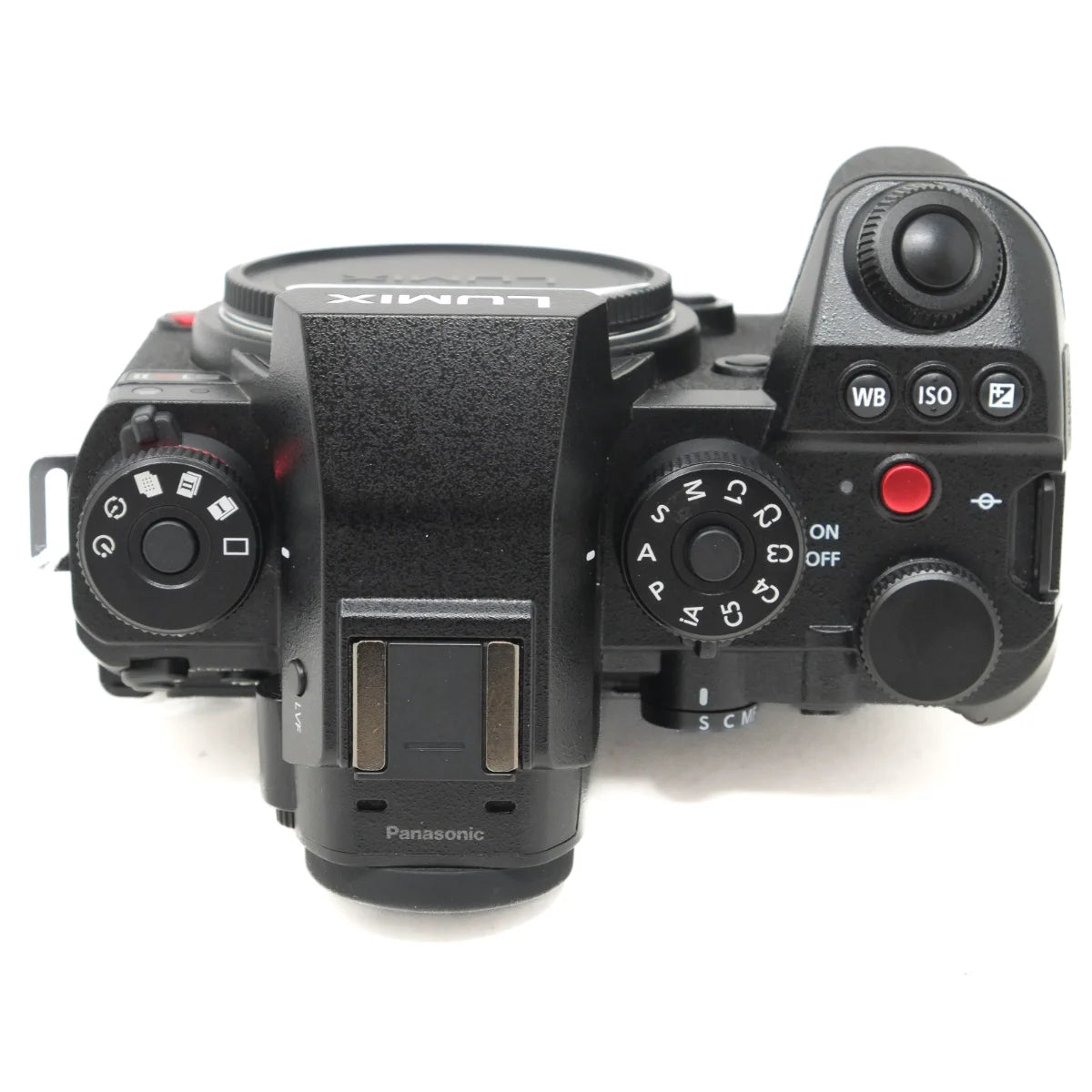 Panasonic Lumix mirrorless camera body top view, showing the dials, buttons, and hot shoe on a white background.