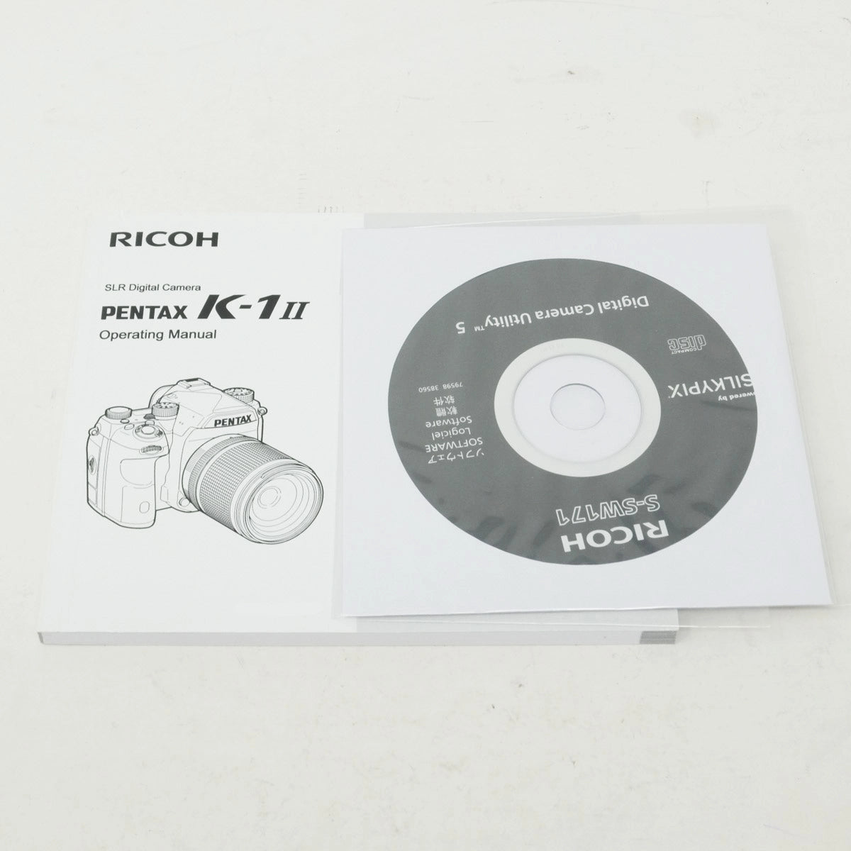 Ricoh Pentax K-1 II camera operating manual and utility CD on a white background