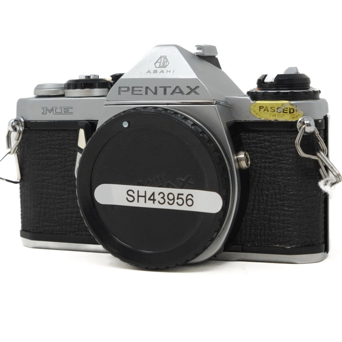 Pentax camera with a black body cap on a white background