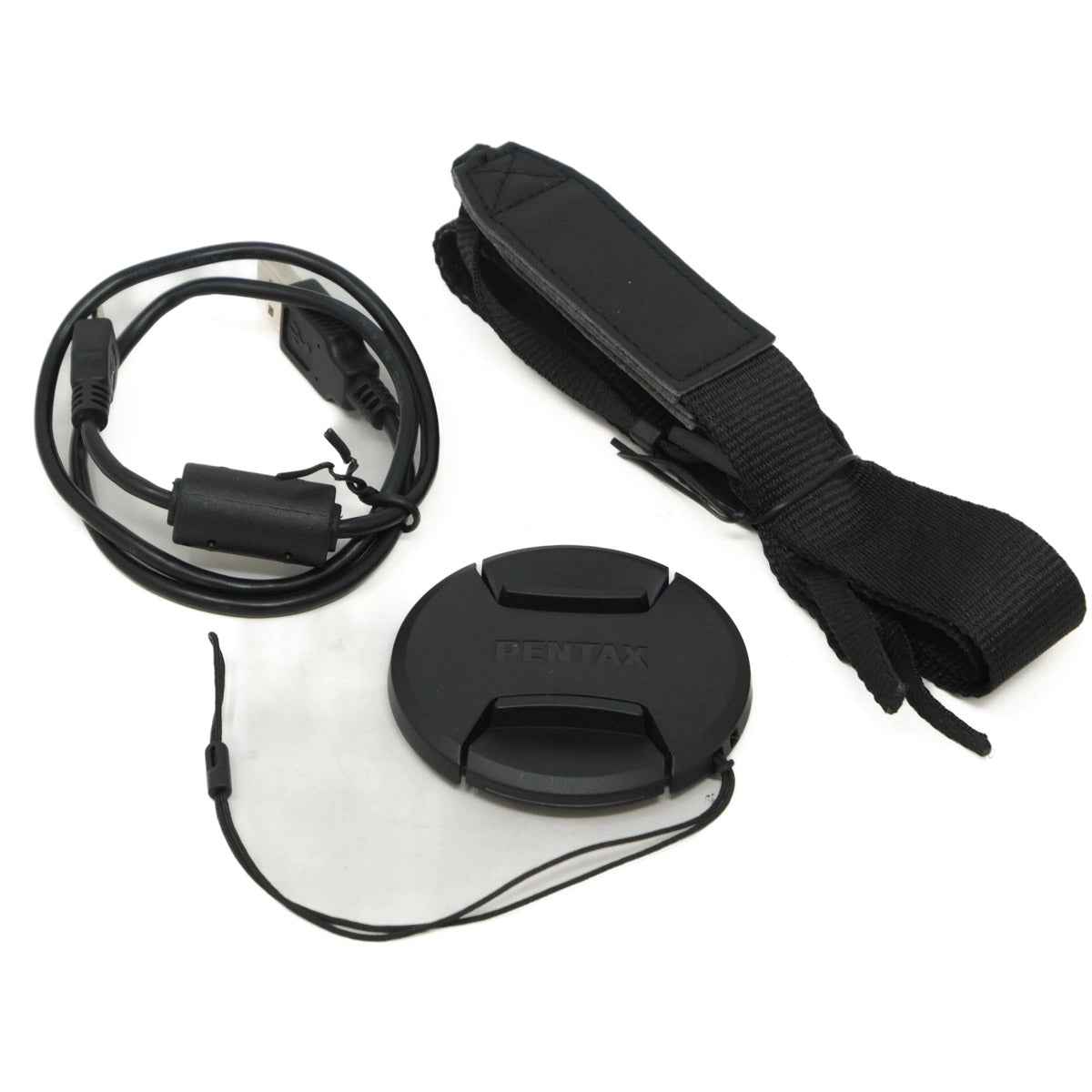 Camera lens cap, cable, and strap on a white background