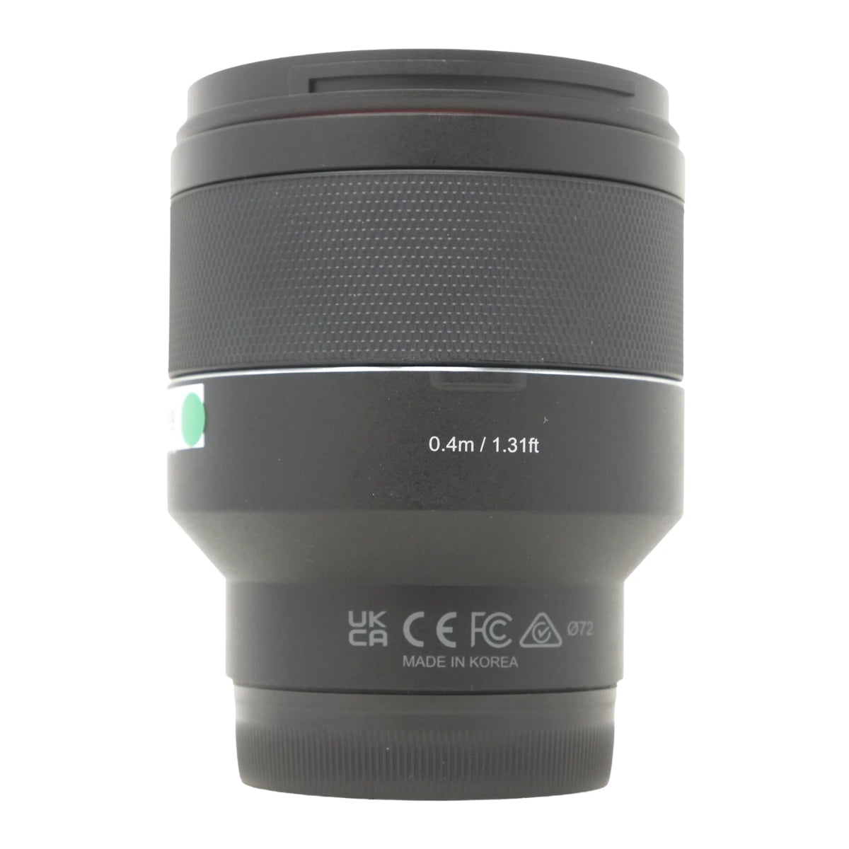 A black camera lens with a textured grip, white text indicating '0.4m / 1.