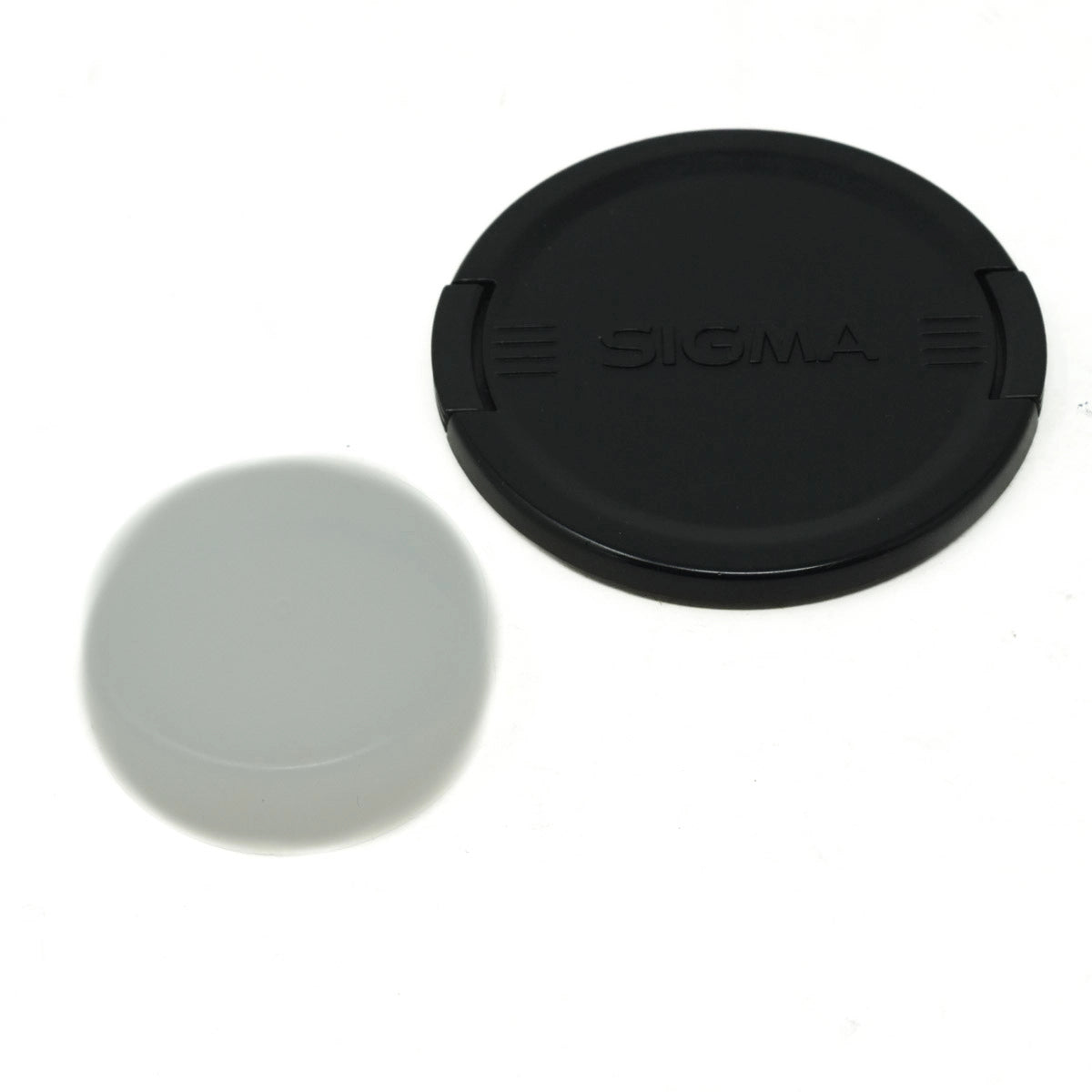 Black lens cap with Sigma logo on a white background