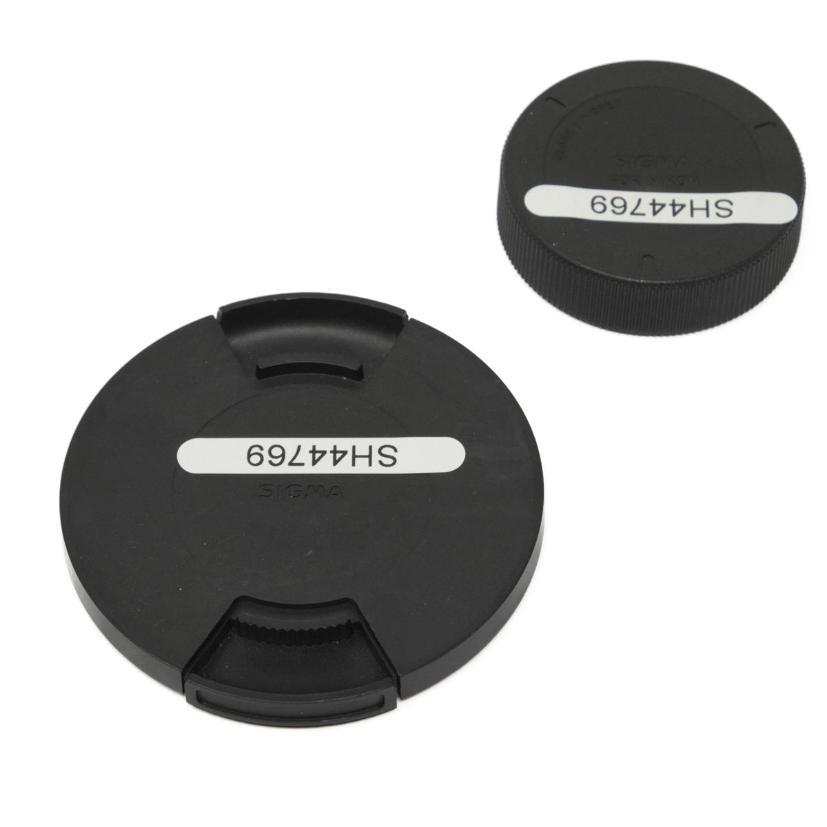 Two black lens caps with 'SH44769' marking on a white background
