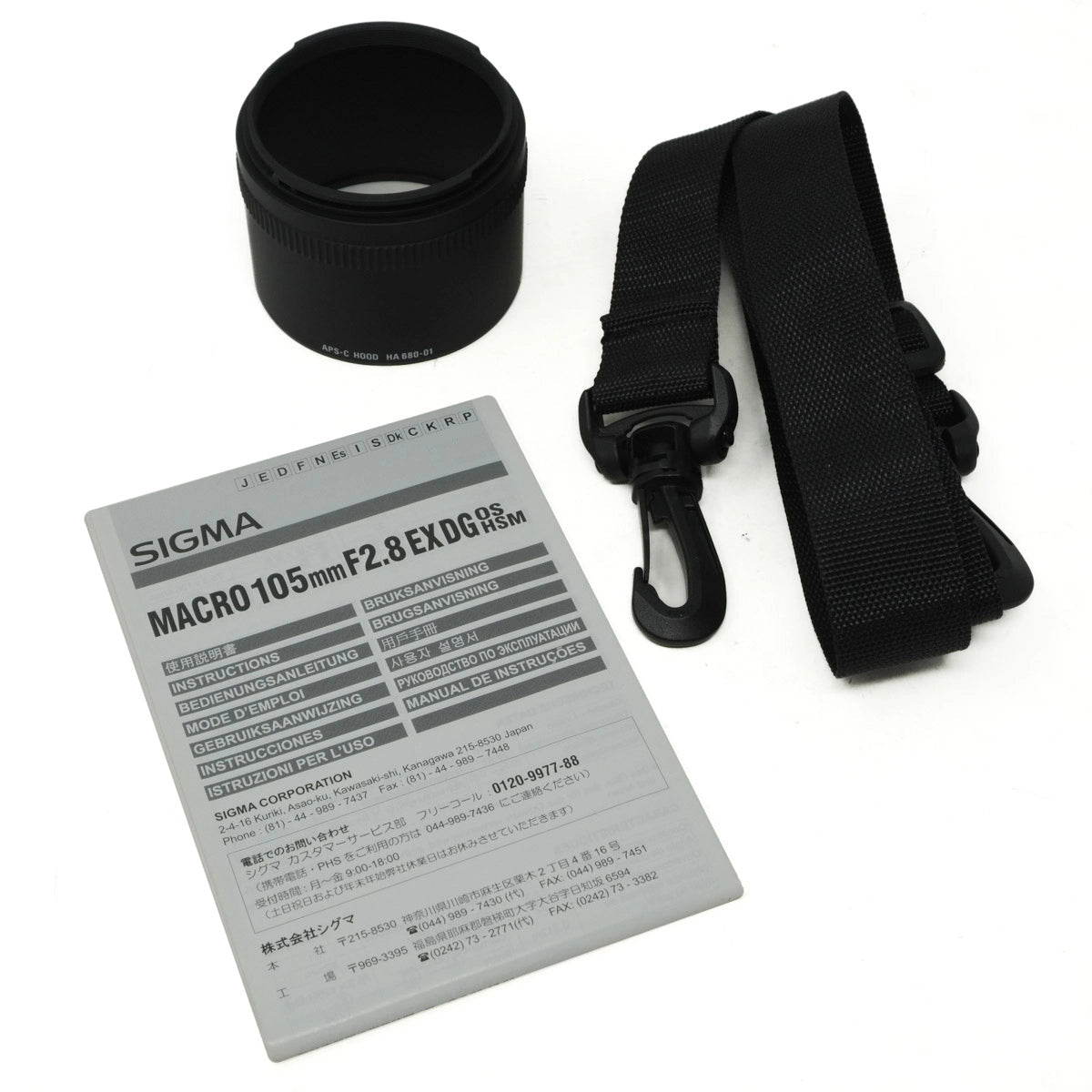 Sigma camera lens with strap and specifications card on a white background