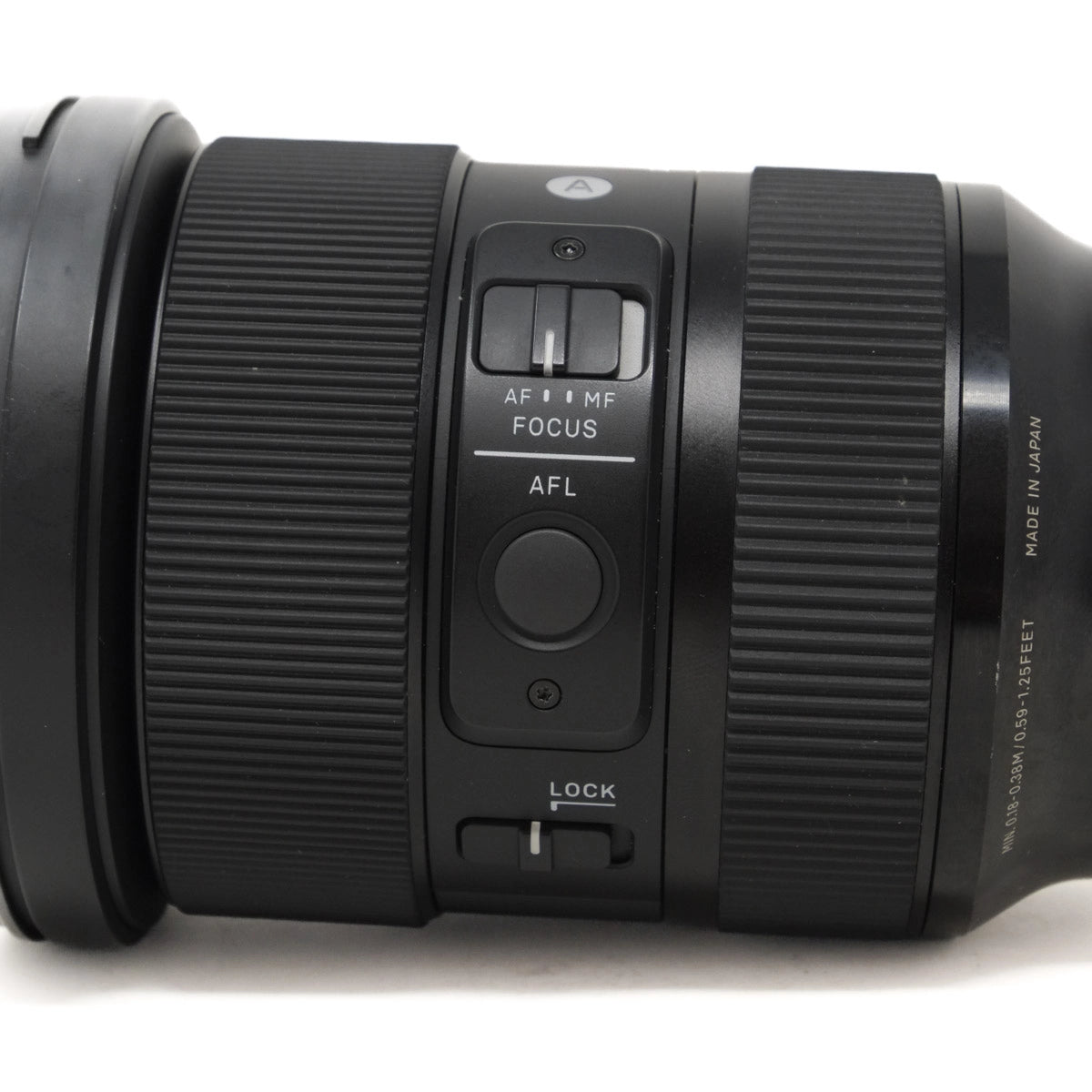 Close-up of a camera lens with focus and lock buttons on a white background