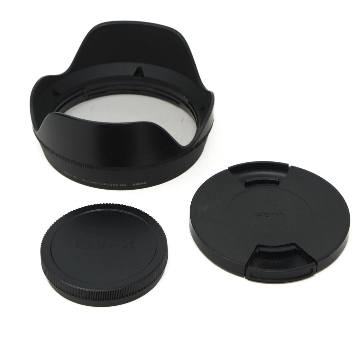 Set of camera lens accessories including a lens hood, front and rear caps on a white background