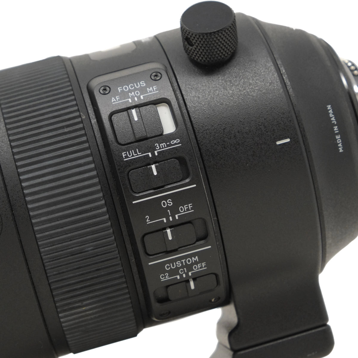 Close-up of a camera lens with control buttons on a white background