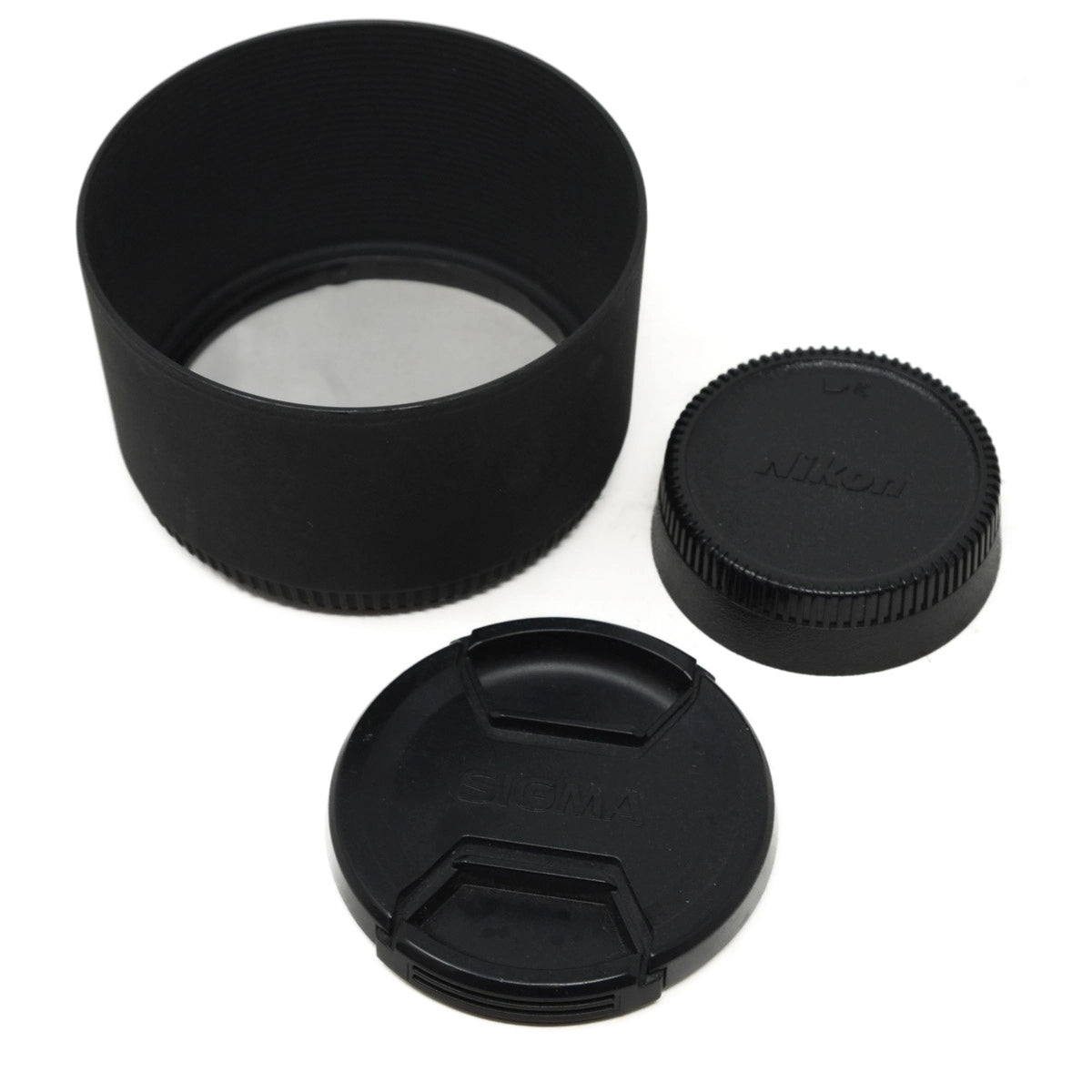 Black camera lens caps and hood with Nikon branding on a white background